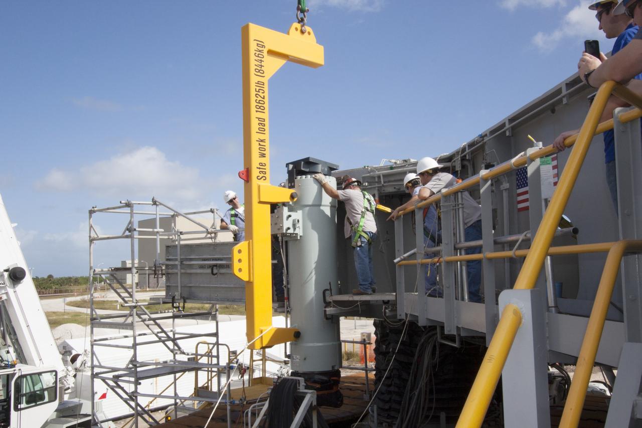 CAPE CANAVERAL, Fla. – Ground support equipment technicians assist as a crane is used to move a new jacking, equalizing and leveling, or JEL, hydraulic cylinder closer for installation on crawler-transporter 1 at the crawler transporter maintenance facility at NASA’s Kennedy Space Center in Florida. New JEL hydraulic cylinders will be installed on CT-1 to test them for increased load carrying capacity and reliability. The Ground Systems Development and Operations Program at Kennedy continues to upgrade CT-1 as part of its general maintenance. CT-1 could be available to carry a variety of launch vehicles to the launch pad. Two crawler-transporters were used to carry the mobile launcher platform and space shuttle to Launch Complex 39 for space shuttle launches for 30 years. Photo credit: NASA/Jim Grossmann