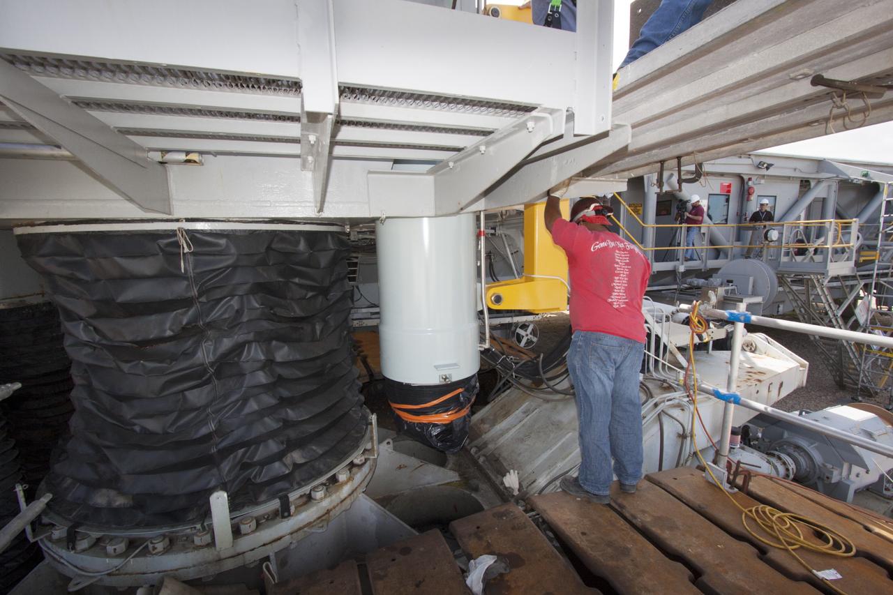 CAPE CANAVERAL, Fla. – Ground support equipment technicians assist as a crane moves a new jacking, equalizing and leveling, or JEL, hydraulic cylinder close for installation on crawler-transporter 1 at the crawler transporter maintenance facility at NASA’s Kennedy Space Center in Florida. New JEL hydraulic cylinders will be installed on CT-1 to test them for increased load carrying capacity and reliability. The Ground Systems Development and Operations Program at Kennedy continues to upgrade CT-1 as part of its general maintenance. CT-1 could be available to carry a variety of launch vehicles to the launch pad. Two crawler-transporters were used to carry the mobile launcher platform and space shuttle to Launch Complex 39 for space shuttle launches for 30 years. Photo credit: NASA/Jim Grossmann