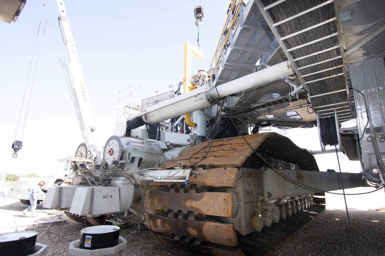 CAPE CANAVERAL, Fla. – Ground support equipment technicians assist as a crane moves a new jacking, equalizing and leveling, or JEL, hydraulic cylinder close for installation on crawler-transporter 1 at the crawler transporter maintenance facility at NASA’s Kennedy Space Center in Florida. New JEL hydraulic cylinders will be installed on CT-1 to test them for increased load carrying capacity and reliability. The Ground Systems Development and Operations Program at Kennedy continues to upgrade CT-1 as part of its general maintenance. CT-1 could be available to carry a variety of launch vehicles to the launch pad. Two crawler-transporters were used to carry the mobile launcher platform and space shuttle to Launch Complex 39 for space shuttle launches for 30 years. Photo credit: NASA/Jim Grossmann