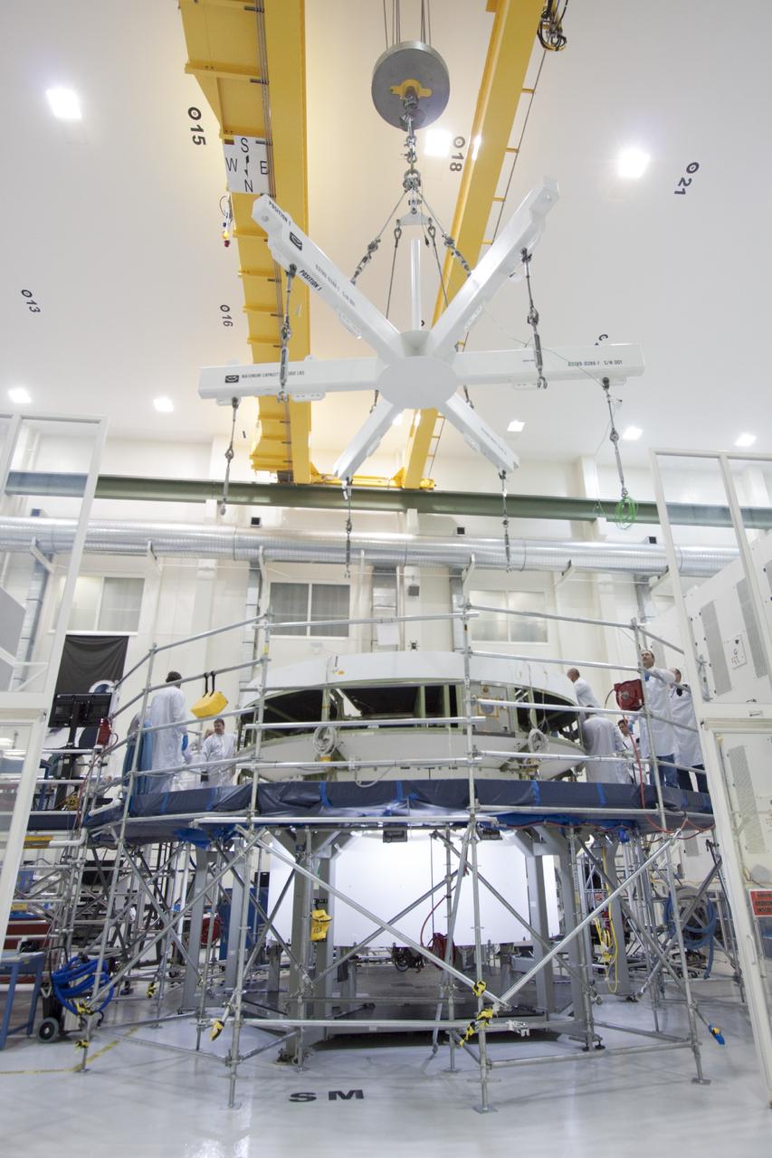 CAPE CANAVERAL, Fla. – Inside the Operations and Checkout Building high bay at NASA’s Kennedy Space Center in Florida, a lifting crane is lowered toward the service module for the Orion spacecraft. The service module will be transferred from the tooling stand onto a lift station where it will be mated to the spacecraft adapter cone. Orion is the exploration spacecraft designed to carry astronauts to destinations not yet explored by humans, including an asteroid and Mars. It will have emergency abort capability, sustain the crew during space travel and provide safe re-entry from deep space return velocities. The first unpiloted test flight of the Orion is scheduled to launch in 2014 atop a Delta IV rocket and in 2017 on NASA’s Space Launch System rocket. For more information, visit http://www.nasa.gov/orion. Photo credit: NASA/Jim Grossmann