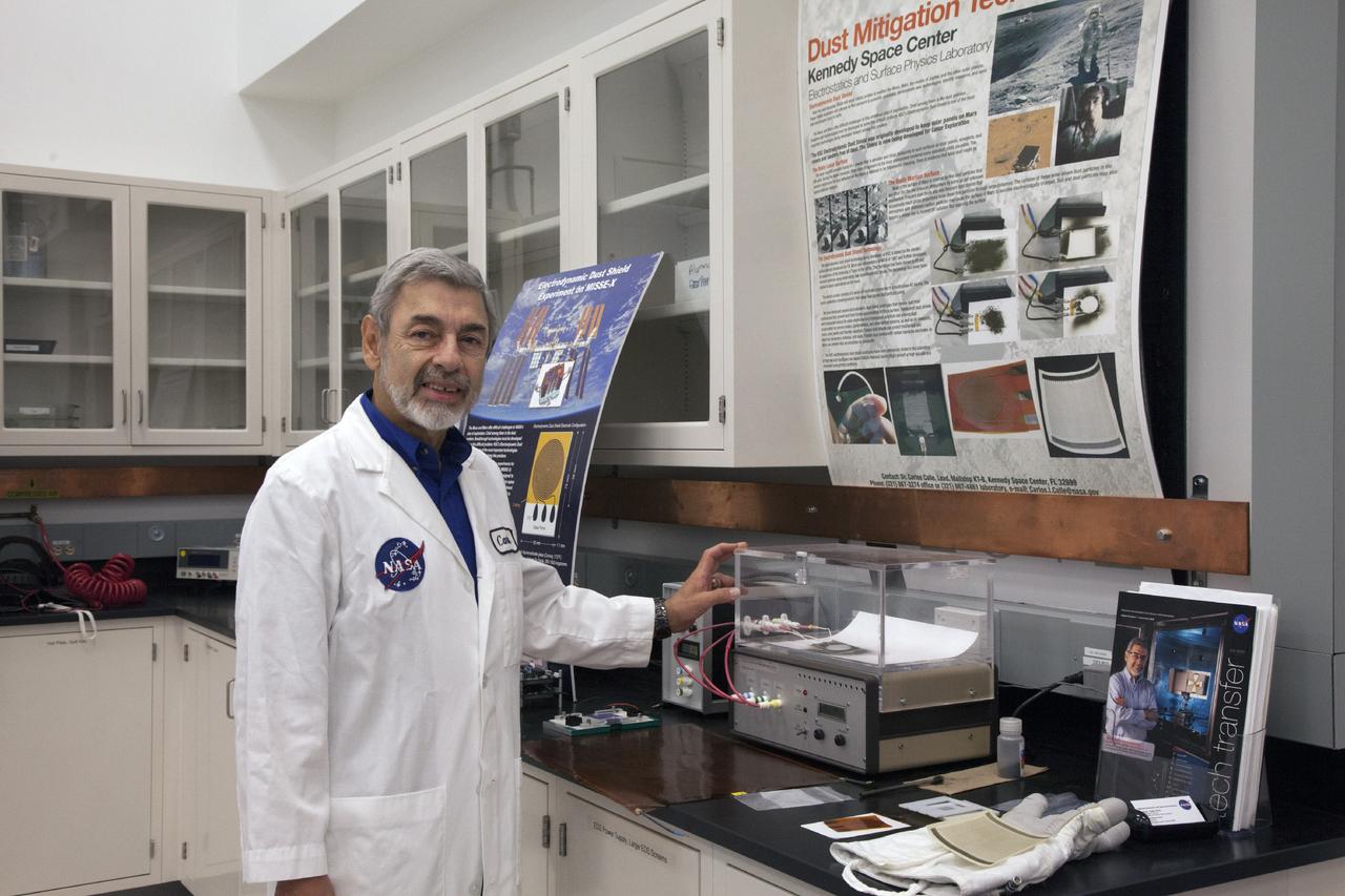 CAPE CANAVERAL, Fla. -- Dr. Carlos Calle, senior research scientist on the Electrodynamic Dust Shield for Dust Mitigation project, demonstrates a dust particle experiment in the Electrostatics and Surface Physics Laboratory in the SwampWorks at NASA's Kennedy Space Center in Florida. The technology works by creating an electric field that propagates out like the ripples on a pond. This could prevent dust accumulation on spacesuits, thermal radiators, solar panels, optical instruments and view ports for future lunar and Mars exploration activities.      Electrodynamic dust shield, or EDS, technology is based on concepts originally developed by NASA as early as 1967 and later by the University of Tokyo. In 2003, NASA, in collaboration with the University of Arkansas at Little Rock, started development of the EDS for dust particle removal from solar panels to be used on future missions to the moon, an asteroid or Mars. A flight experiment to expose the dust shields to the space environment currently is under development. For more information, visit: http://www.nasa.gov/content/scientists-developing-ways-to-mitigate-dust-problem-for-explorers/ Photo credit: NASA/Dan Casper