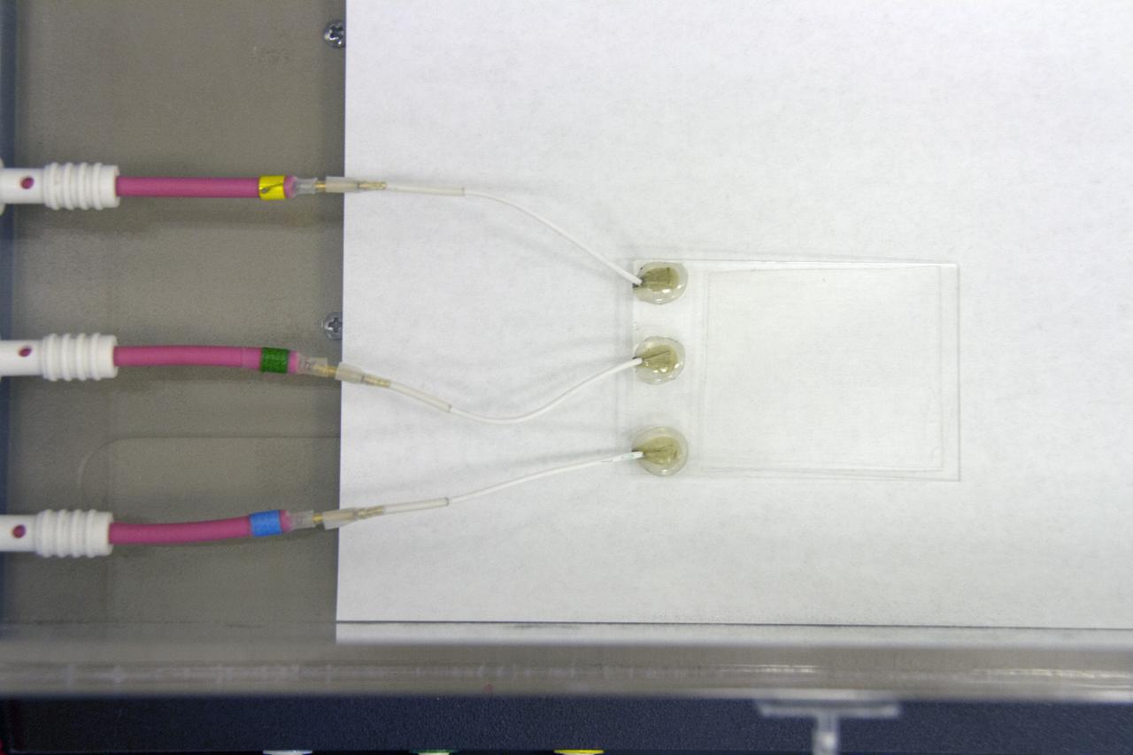 CAPE CANAVERAL, Fla. -- Preparations are underway to conduct a dust particle experiment for the Electrodynamic Dust Shield for Dust Mitigation project in the Electrostatics and Surface Physics Laboratory in the SwampWorks at NASA's Kennedy Space Center in Florida. The technology works by creating an electric field that propagates out like the ripples on a pond. This could prevent dust accumulation on spacesuits, thermal radiators, solar panels, optical instruments and view ports for future lunar and Mars exploration activities. CAPE CANAVERAL, Fla. -- Preparations are underway to conduct a dust particle experiment for the Electrodynamic Dust Shield for Dust Mitigation project in the Electrostatics and Surface Physics Laboratory in the SwampWorks at NASA's Kennedy Space Center in Florida. The technology works by creating an electric field that propagates out like the ripples on a pond. This could prevent dust accumulation on spacesuits, thermal radiators, solar panels, optical instruments and view ports for future lunar and Mars exploration activities.