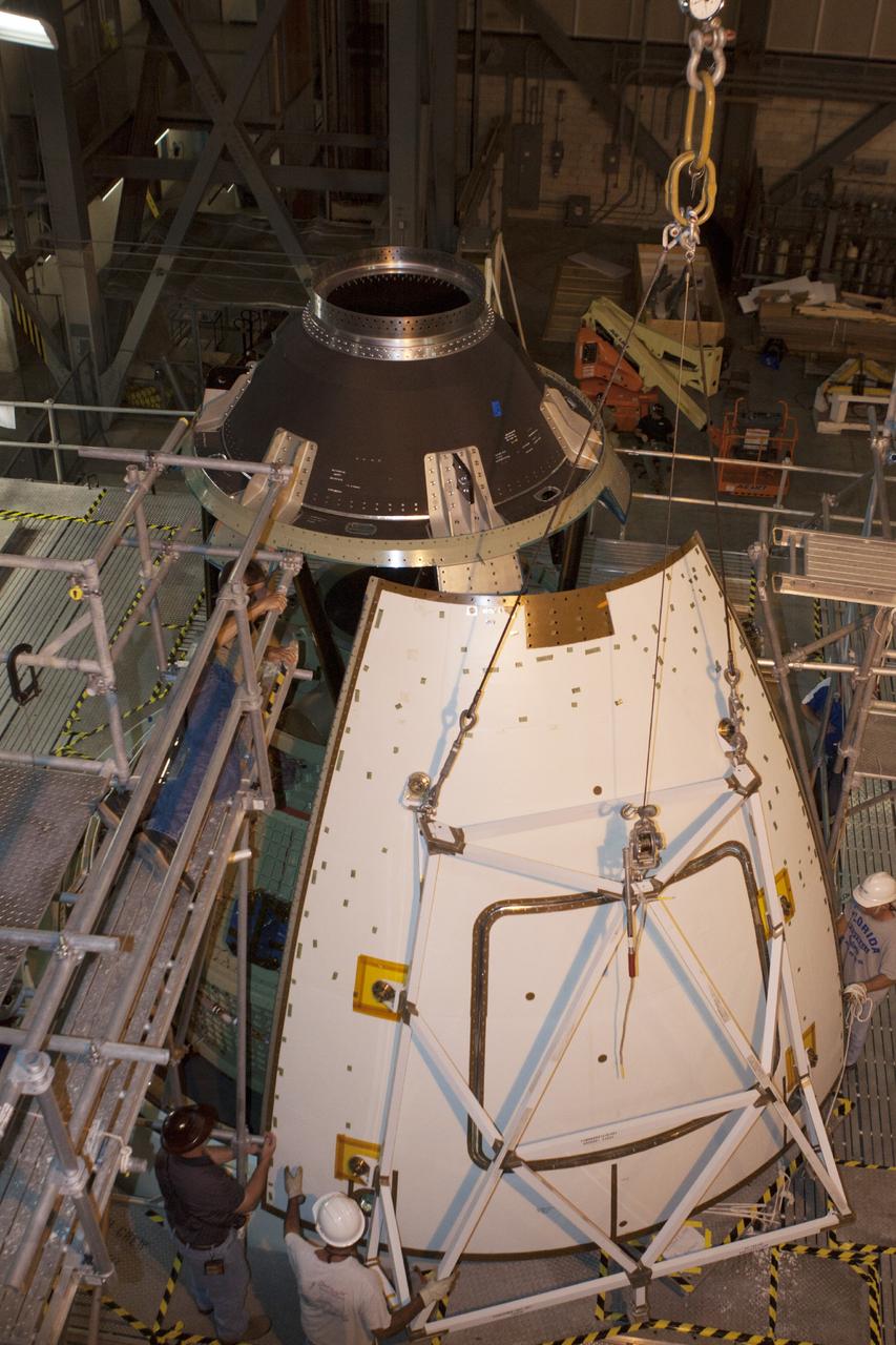 CAPE CANAVERAL, Fla. – At NASA’s Kennedy Space Center in Florida, technicians assist as a crane is used to move one of four ogive panels closer for installation on the Orion ground test vehicle in Vehicle Assembly Building high bay 4. The ogive panels enclose and protect the Orion spacecraft and attach to the Launch Abort System. The test vehicle is being used by the Ground Systems Development and Operations Program for path finding operations, including simulated manufacturing, assembly and stacking procedures. Orion is the exploration spacecraft designed to carry astronauts to destinations not yet explored by humans, including an asteroid and Mars. It will have emergency abort capability, sustain the crew during space travel and provide safe re-entry from deep space return velocities. The first unpiloted test flight of Orion is scheduled to launch in 2014 atop a Delta IV rocket and in 2017 on NASA’s Space Launch System rocket. For more information, visit www.nasa.gov/orion. Photo credit: Kim Shiflett