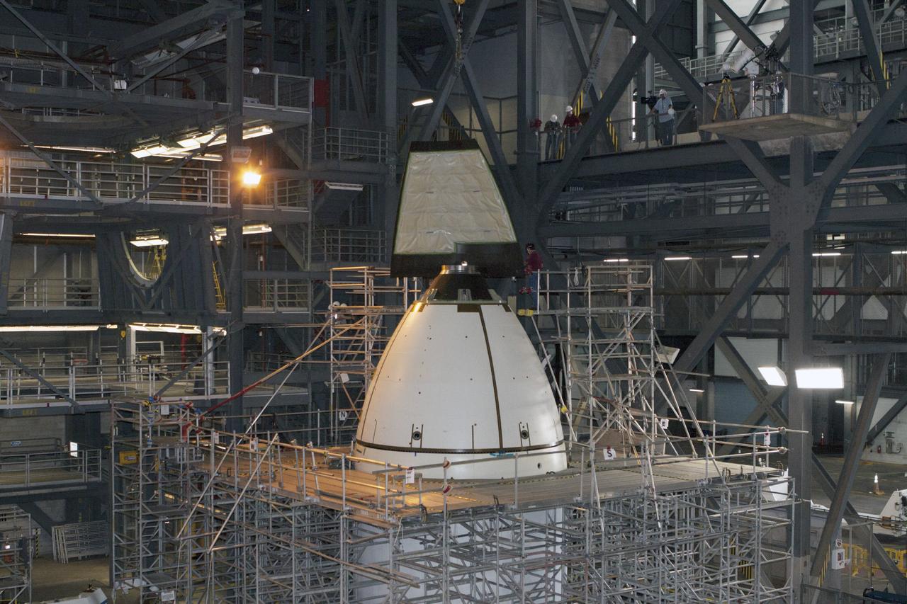 CAPE CANAVERAL, Fla. – At NASA’s Kennedy Space Center in Florida, technicians monitor the progress as the fourth ogive panel is lifted by crane so that they can be installed on the Orion ground test vehicle in Vehicle Assembly Building high bay 4. Three of the panels have already been installed on the test vehicle. The ogive panels enclose and protect the Orion spacecraft and attach to the Launch Abort System. The test vehicle is being used by the Ground Systems Development and Operations Program for path finding operations, including simulated manufacturing, assembly and stacking procedures. Orion is the exploration spacecraft designed to carry astronauts to destinations not yet explored by humans, including an asteroid and Mars. It will have emergency abort capability, sustain the crew during space travel and provide safe re-entry from deep space return velocities. The first unpiloted test flight of Orion is scheduled to launch in 2014 atop a Delta IV rocket and in 2017 on NASA’s Space Launch System rocket. For more information, visit www.nasa.gov/orion. Photo credit: Kim Shiflett