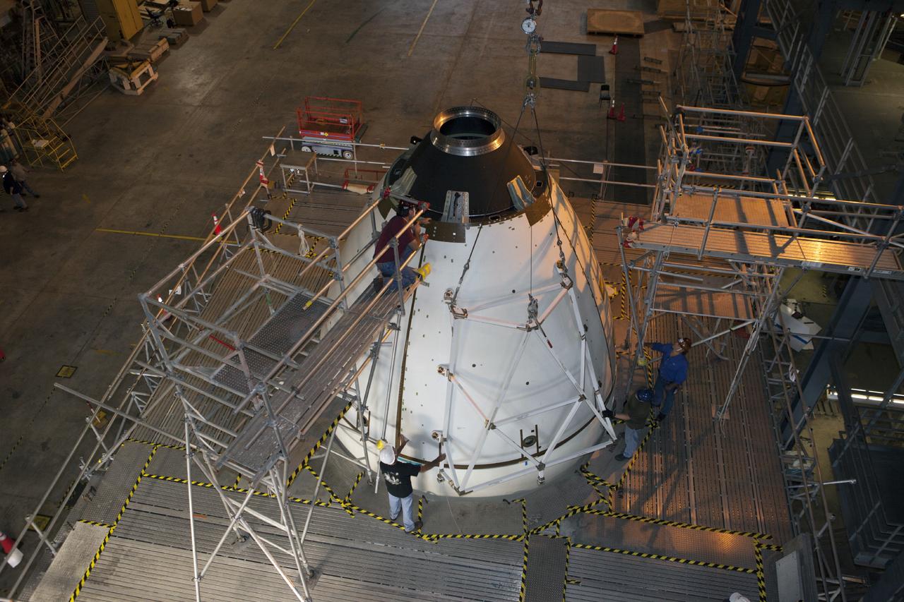 CAPE CANAVERAL, Fla. – At NASA’s Kennedy Space Center in Florida, technicians attach the fourth ogive panel on the Orion ground test vehicle in Vehicle Assembly Building high bay 4. The ogive panels enclose and protect the Orion spacecraft and attach to the Launch Abort System. The test vehicle is being used by the Ground Systems Development and Operations Program for path finding operations, including simulated manufacturing, assembly and stacking procedures. Orion is the exploration spacecraft designed to carry astronauts to destinations not yet explored by humans, including an asteroid and Mars. It will have emergency abort capability, sustain the crew during space travel and provide safe re-entry from deep space return velocities. The first unpiloted test flight of Orion is scheduled to launch in 2014 atop a Delta IV rocket and in 2017 on NASA’s Space Launch System rocket. For more information, visit www.nasa.gov/orion. Photo credit: Kim Shiflett