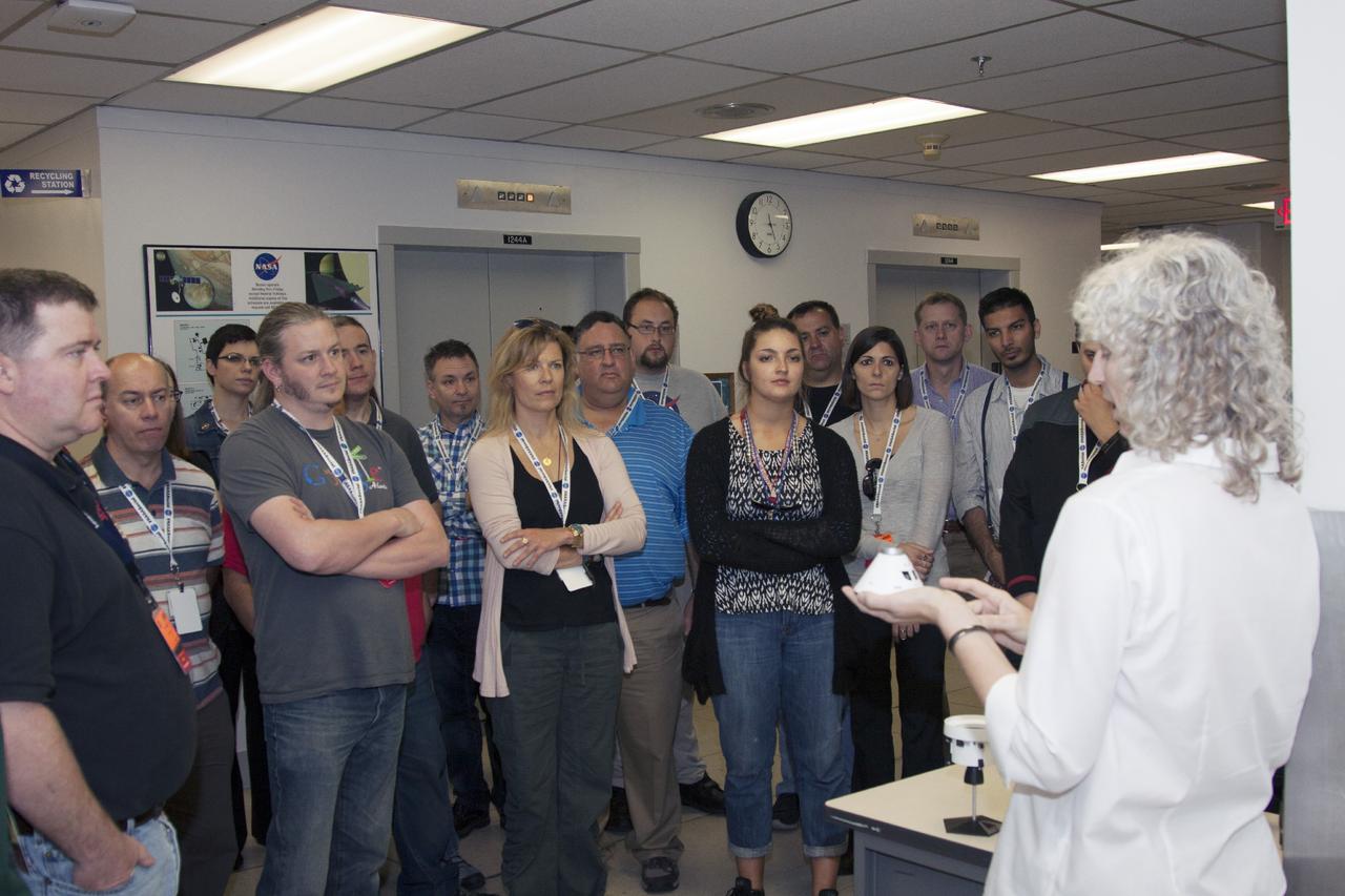 CAPE CANAVERAL, Fla. -- Social media participants are briefed on the Orion spacecraft by Sharolee Huet of NASA Operational Processing in Safety and Mission Assurance at NASA's Kennedy Space Center in Florida. The participants were on hand for the upcoming launch of the Mars Atmosphere and Volatile Evolution, or MAVEN, mission.      Their visit included tours of key facilities at the Florida Spaceport and participating in presentations by key NASA leaders who updated the space agency's current efforts. Photo credit: NASA/Jim Grossman