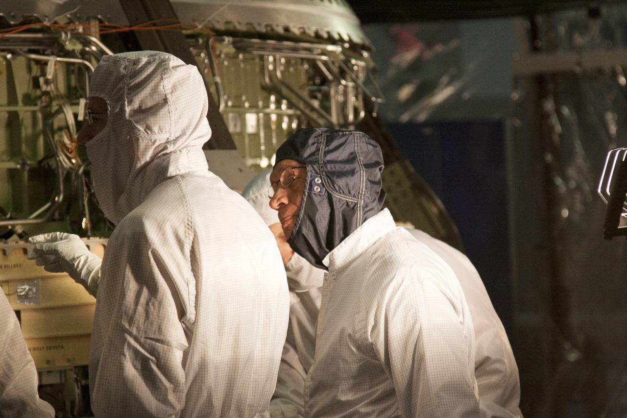 CAPE CANAVERAL, Fla. – Inside the Operations and Checkout Building high bay at NASA’s Kennedy Space Center in Florida, agency Administrator Charles Bolden, center, is updated on activities to prepare the Orion spacecraft crew module for its first unpiloted launch, Exploration Test Flight 1. He is wearing a protective garment to ensure contaminants are not introduced into the cleanroom environment.      Orion is the exploration spacecraft designed to carry crews to space beyond low Earth orbit. It will provide emergency abort capability, sustain the crew during the space travel and provide safe re-entry from deep space return velocities. Orion’s first unpiloted test launch is scheduled for liftoff during 2014 atop a Delta IV rocket. A second unpiloted flight test is scheduled for 2017 on NASA’s Space Launch System rocket. For more information, visit http://www.nasa.gov/orion Photo credit: NASA/Jim Grossman