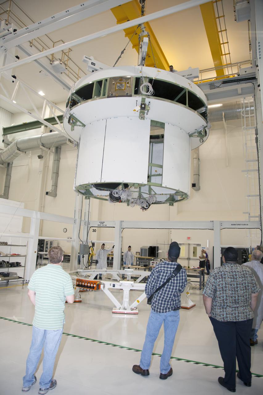 CAPE CANAVERAL, Fla. -- Inside the Operations and Checkout Building high bay at NASA’s Kennedy Space Center in Florida, technicians monitor the progress as the service module bulkhead for the Orion spacecraft is lifted by crane from a work stand. The service module will be mated to the spacecraft adapter cone for testing. Orion is the exploration spacecraft designed to carry astronauts to destinations not yet explored by humans, including an asteroid and Mars. It will have emergency abort capability, sustain the crew during space travel and provide safe re-entry from deep space return velocities. The first unpiloted test flight of the Orion is scheduled to launch in 2014 atop a Delta IV rocket and in 2017 on NASA’s Space Launch System rocket. For more information, visit http://www.nasa.gov/orion. Photo credit: NASA/Daniel Casper