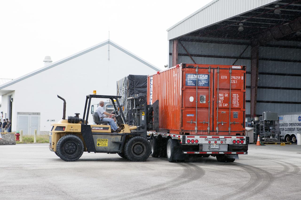 CAPE CANAVERAL, Fla. -- At NASA’s Kennedy Space Center in Florida, a flatbed truck carrying the Project Morpheus lander arrives at a support building at the Shuttle Landing Facility, or SLF. Testing of the prototype lander has been ongoing at NASA’s Johnson Space Center in Houston in preparation for free flight testing at Kennedy. The SLF will provide the lander with the kind of field necessary for realistic testing, complete with rocks, craters and hazards to avoid. Morpheus utilizes an autonomous landing and hazard avoidance technology, or ALHAT, payload that will allow it to navigate to clear landing sites amidst rocks, craters and other hazards during its descent. Project Morpheus is one of 20 small projects comprising the Advanced Exploration Systems, or AES, program in NASA’s Human Exploration and Operations Mission Directorate. AES projects pioneer new approaches for rapidly developing prototype systems, demonstrating key capabilities and validating operational concepts for future human missions beyond Earth orbit. For more information on Project Morpheus, visit http://www.nasa.gov/centers/johnson/exploration/morpheus/index.html. Photo credit: NASA/Kim Shiflett