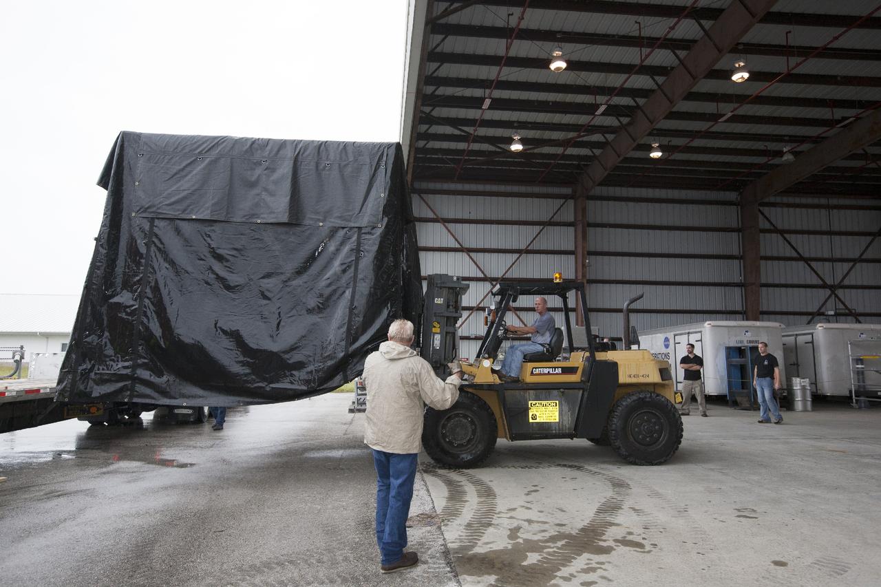 CAPE CANAVERAL, Fla. -- At NASA’s Kennedy Space Center in Florida, the Project Morpheus lander is moved into a support building at the Shuttle Landing Facility, or SLF. Testing of the prototype lander has been ongoing at NASA’s Johnson Space Center in Houston in preparation for free flight testing at Kennedy. The SLF will provide the lander with the kind of field necessary for realistic testing, complete with rocks, craters and hazards to avoid. Morpheus utilizes an autonomous landing and hazard avoidance technology, or ALHAT, payload that will allow it to navigate to clear landing sites amidst rocks, craters and other hazards during its descent. Project Morpheus is one of 20 small projects comprising the Advanced Exploration Systems, or AES, program in NASA’s Human Exploration and Operations Mission Directorate. AES projects pioneer new approaches for rapidly developing prototype systems, demonstrating key capabilities and validating operational concepts for future human missions beyond Earth orbit. For more information on Project Morpheus, visit http://www.nasa.gov/centers/johnson/exploration/morpheus/index.html. Photo credit: NASA/Kim Shiflett