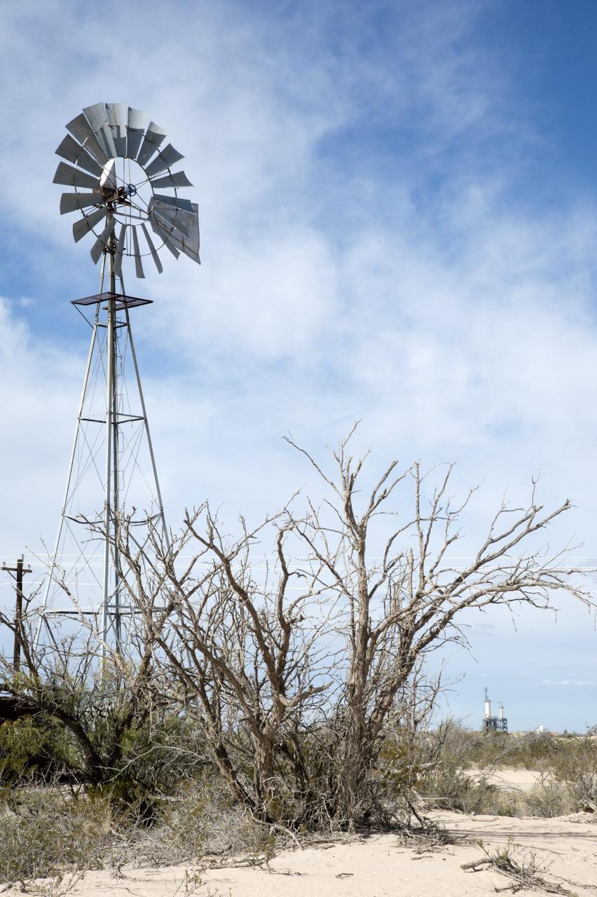 VAN HORN, Texas – Blue Origin’s test stand, back right, is framed by a wind mill at the company’s West Texas facility. The company used this test stand to fire its powerful new hydrogen- and oxygen-fueled American rocket engine, the BE-3. The engine fired at full power for more than two minutes to simulate a launch, then paused for about four minutes, mimicking a coast through space before it re-ignited for a brief final burn. The last phase of the test covered the work the engine could perform in landing the booster back softly on Earth. Blue Origin, a partner of NASA’s Commercial Crew Program, or CCP, is developing its Orbital Launch Vehicle, which could eventually be used to launch the company's Space Vehicle into orbit to transport crew and cargo to low-Earth orbit. CCP is aiding in the innovation and development of American-led commercial capabilities for crew transportation and rescue services to and from the station and other low-Earth orbit destinations by the end of 2017. For information about CCP, visit www.nasa.gov/commercialcrew. Photo credit: NASA/Lauren Harnett