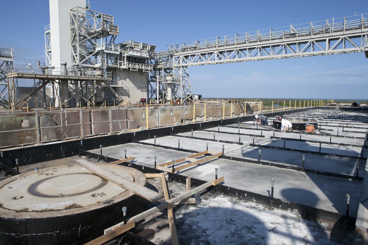 CAPE CANAVERAL, Fla. -- At Launch Pad 39B at NASA’s Kennedy Space Center in Florida, all of the old crawler track panels have been removed from the surface and construction workers are repairing the concrete surface and catacomb roof below.  At far left is the recently-constructed pad elevator.      Launch Pad 39B is being refurbished to support NASA’s Space Launch System and other launch vehicles. The Ground Systems Development and Operations, or GSDO, Program office at Kennedy is leading the center’s transformation to safely handle a variety of rockets and spacecraft. For more information about GSDO, visit: http://go.nasa.gov/groundsystems.  Photo credit: NASA/Kim Shiflett