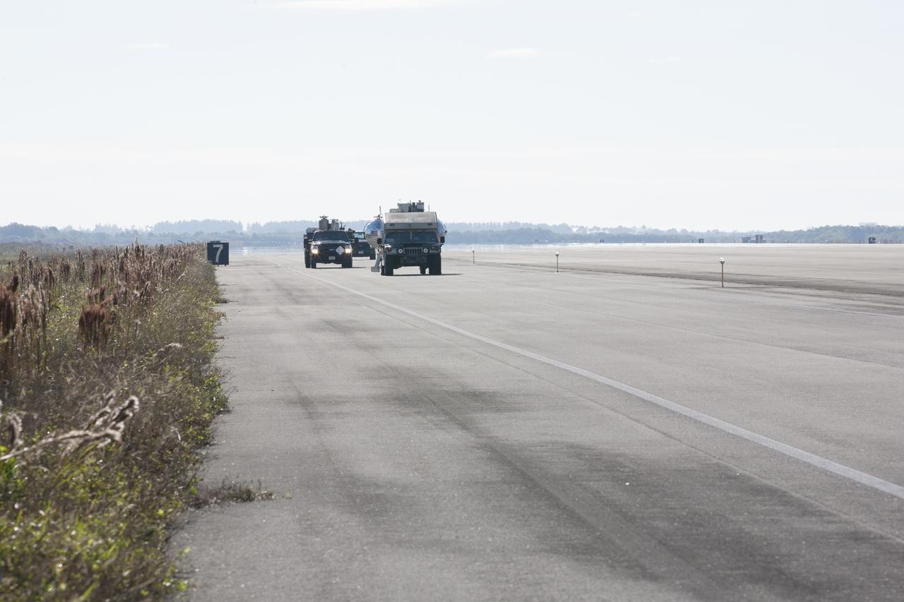 CAPE CANAVERAL, Fla. -- At NASA’s Kennedy Space Center in Florida, a convoy of vehicles accompanies the Project Morpheus prototype lander as it is transported to a launch platform at the north end of the Shuttle Landing Facility. Testing of the prototype lander has been ongoing at NASA’s Johnson Space Center in Houston in preparation for tethered and free flight testing at Kennedy. The landing facility will provide the lander with the kind of field necessary for realistic testing, complete with rocks, craters and hazards to avoid. Morpheus utilizes an autonomous landing and hazard avoidance technology, or ALHAT, payload that will allow it to navigate to clear landing sites amidst rocks, craters and other hazards during its descent. Project Morpheus is being managed under the Advanced Exploration Systems, or AES, Division in NASA’s Human Exploration and Operations Mission Directorate. The efforts in AES pioneer new approaches for rapidly developing prototype systems, demonstrating key capabilities and validating operational concepts for future human missions beyond Earth orbit. For more information on Project Morpheus, visit http://morpheuslander.jsc.nasa.gov. Photo credit: NASA/Kim Shiflett