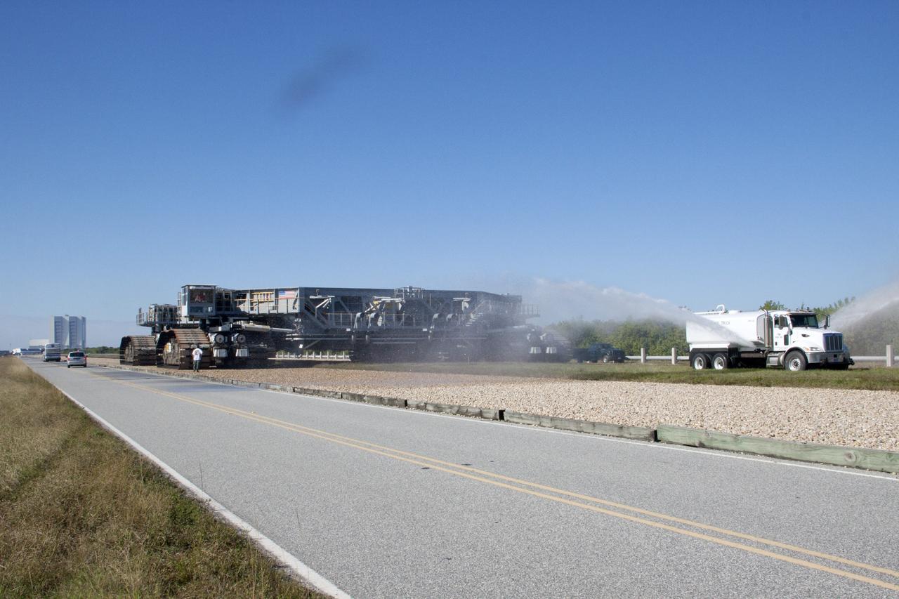 CAPE CANAVERAL, Fla. -- A truck sprays water along the crawlerway to reduce dust ahead of crawler-transporter 1 as it continues its trek to Launch Pad 39A at NASA’s Kennedy Space Center in Florida. New jacking, equalizing and leveling, or JEL, hydraulic cylinders were installed on CT-1 and will be tested for increased load carrying capacity and reliability. The Ground Systems Development and Operations Program at Kennedy continues to upgrade the crawler-transporter as part of its general maintenance. CT-1 could be available to carry a variety of launch vehicles to the launch pad. Two crawler-transporters were used to carry the mobile launcher platform and space shuttle to Launch Complex 39 for space shuttle launches for 30 years. Photo credit: NASA/Jim Grossmann