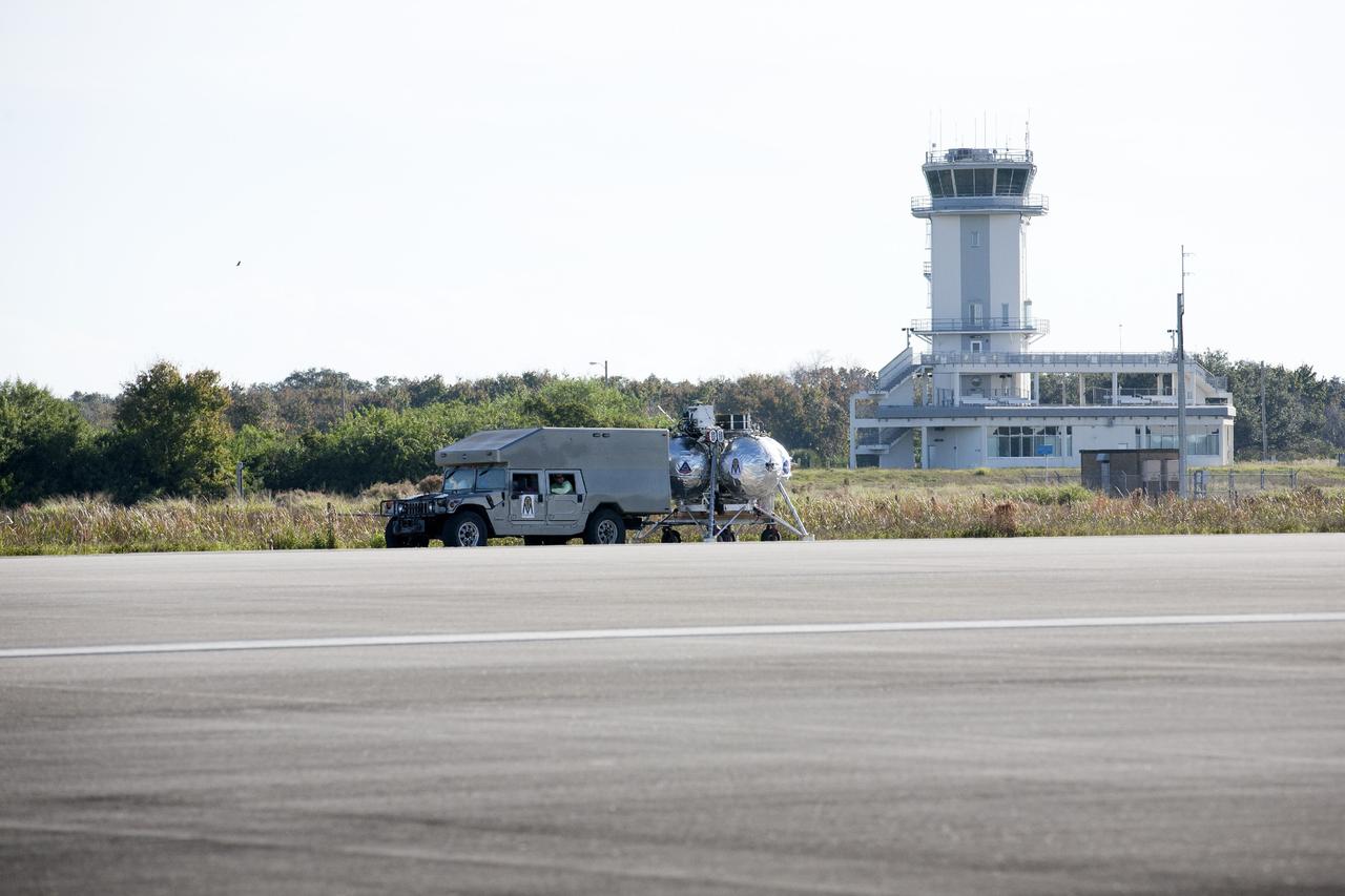 CAPE CANAVERAL, Fla. – The Project Morpheus prototype lander is positioned at the midfield of the Shuttle Landing Facility at NASA’s Kennedy Space Center in Florida to prepare it for a dress rehearsal of a tethered flight test. The lander will be transported to a launch platform at the north end of the landing facility. Testing of the prototype lander was performed at NASA’s Johnson Space Center in Houston in preparation for tethered and free flight testing at Kennedy. The landing facility will provide the lander with the kind of field necessary for realistic testing, complete with rocks, craters and hazards to avoid. Morpheus utilizes an autonomous landing and hazard avoidance technology, or ALHAT, payload that will allow it to navigate to clear landing sites amidst rocks, craters and other hazards during its descent. Project Morpheus is being managed under the Advanced Exploration Systems, or AES, Division in NASA’s Human Exploration and Operations Mission Directorate. The efforts in AES pioneer new approaches for rapidly developing prototype systems, demonstrating key capabilities and validating operational concepts for future human missions beyond Earth orbit. For more information on Project Morpheus, visit http://morpheuslander.jsc.nasa.gov. Photo credit: NASA/Kim Shiflett