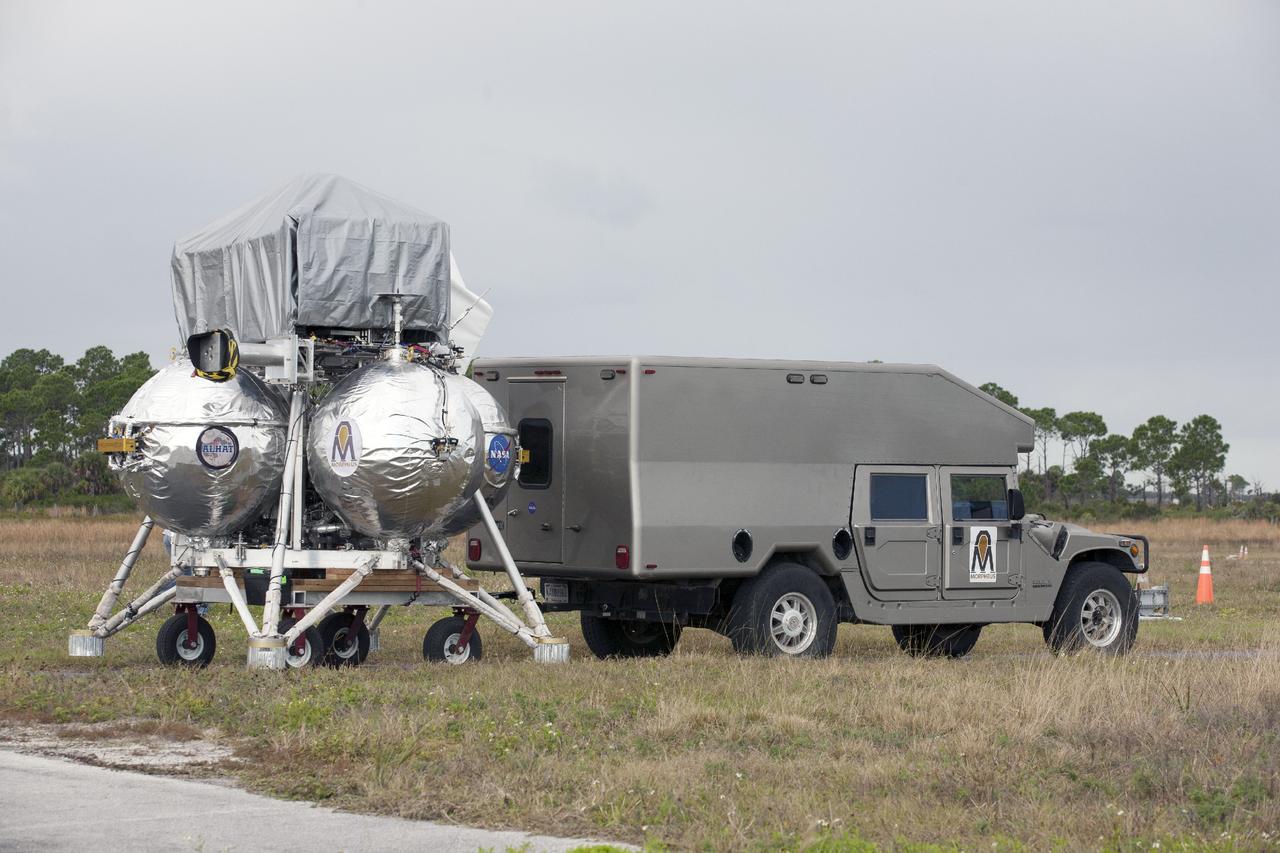CAPE CANAVERAL, Fla. – At NASA’s Kennedy Space Center in Florida, the Project Morpheus prototype lander is being prepared for placement on a transportable launch platform positioned at the north end of the Shuttle Landing Facility. The lander will be prepared for a tethered test that includes lifting it 20 feet by crane, ascending another 10 feet, maneuvering backwards 10 feet, and then flying forward and descending to its original position, landing at the end of the tether. Testing of the prototype lander was performed at NASA’s Johnson Space Center in Houston in preparation for tethered and free flight testing at Kennedy. The landing facility will provide the lander with the kind of field necessary for realistic testing, complete with rocks, craters and hazards to avoid. Morpheus utilizes an autonomous landing and hazard avoidance technology, or ALHAT, payload that will allow it to navigate to clear landing sites amidst rocks, craters and other hazards during its descent. Project Morpheus is being managed under the Advanced Exploration Systems, or AES, Division in NASA’s Human Exploration and Operations Mission Directorate. The efforts in AES pioneer new approaches for rapidly developing prototype systems, demonstrating key capabilities and validating operational concepts for future human missions beyond Earth orbit. For more information on Project Morpheus, visit http://morpheuslander.jsc.nasa.gov. Photo credit: NASA/Kim Shiflett