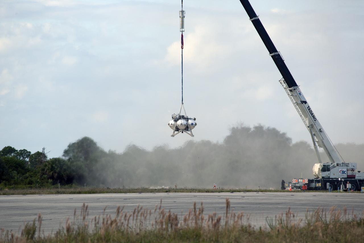 CAPE CANAVERAL, Fla. – At NASA’s Kennedy Space Center in Florida, the Project Morpheus prototype lander’s engine has completed its firing during a tether test at the north end of the Shuttle Landing Facility. During the test, the lander was lifted 20 feet by crane, and then ascended another 10 feet, maneuvered backwards 10 feet, and then flew forward. It will descend to its original position, landing at the end of the tether onto a transportable launch platform. Testing of the prototype lander was performed at NASA’s Johnson Space Center in Houston in preparation for tethered and free flight testing at Kennedy. The landing facility will provide the lander with the kind of field necessary for realistic testing, complete with rocks, craters and hazards to avoid. Morpheus utilizes an autonomous landing and hazard avoidance technology, or ALHAT, payload that will allow it to navigate to clear landing sites amidst rocks, craters and other hazards during its descent. Project Morpheus is being managed under the Advanced Exploration Systems, or AES, Division in NASA’s Human Exploration and Operations Mission Directorate. The efforts in AES pioneer new approaches for rapidly developing prototype systems, demonstrating key capabilities and validating operational concepts for future human missions beyond Earth orbit. For more information on Project Morpheus, visit http://morpheuslander.jsc.nasa.gov. Photo credit: NASA/Daniel Casper