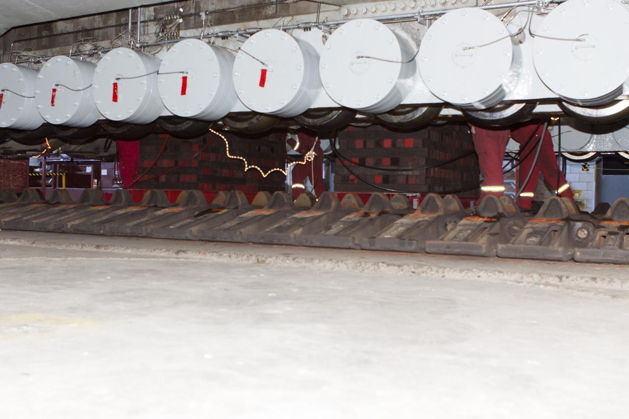 CAPE CANAVERAL, Fla. – Inside the Vehicle Assembly Building at NASA’s Kennedy Space Center in Florida, preparations are underway to lower crawler-transporter 2, or CT-2, from jack stands so that work can begin to re-stall the large crawler tracks. The crawler is being prepared for rollout in January 2014 to test the new bearings that were recently installed.    Work continues in high bay 2 to upgrade CT-2. The modifications are designed to ensure CT-2’s ability to transport launch vehicles currently in development, such as the agency’s Space Launch System, to the launch pad. The Ground Systems Development and Operations Program office at Kennedy is overseeing the upgrades. For more than 45 years the crawler-transporters were used to transport the mobile launcher platform and the Apollo-Saturn V rockets and, later, space shuttles to Launch Pads 39A and B. For more information, visit: http://www.nasa.gov/centers/kennedy/pdf/638823main_crawler-transporter.pdf. Photo credit: NASA/Jim Grossmann