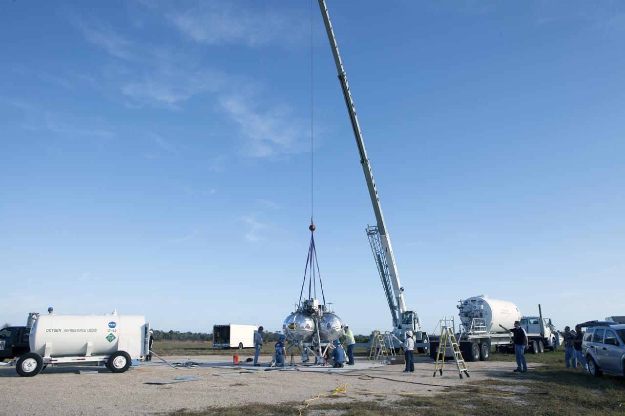 CAPE CANAVERAL, Fla. – Preparations are underway to prepare the Project Morpheus prototype lander for its first free flight test at the north end of the Shuttle Landing Facility at NASA’s Kennedy Space Center in Florida. Testing of the prototype lander was performed at NASA’s Johnson Space Center in Houston in preparation for tethered and free flight testing at Kennedy. Project Morpheus integrates NASA’s automated landing and hazard avoidance technology, or ALHAT, with an engine that runs on liquid oxygen and methane, or green propellants, into a fully-operational lander that could deliver cargo to asteroids and other planetary surfaces.      The landing facility will provide the lander with the kind of field necessary for realistic testing, complete with rocks, craters and hazards to avoid. Morpheus’ ALHAT payload allows it to navigate to clear landing sites amidst rocks, craters and other hazards during its descent. Project Morpheus is being managed under the Advanced Exploration Systems, or AES, Division in NASA’s Human Exploration and Operations Mission Directorate. The efforts in AES pioneer new approaches for rapidly developing prototype systems, demonstrating key capabilities and validating operational concepts for future human missions beyond Earth orbit. For more information on Project Morpheus, visit http://morpheuslander.jsc.nasa.gov.  Photo credit: NASA/Kim Shiflett