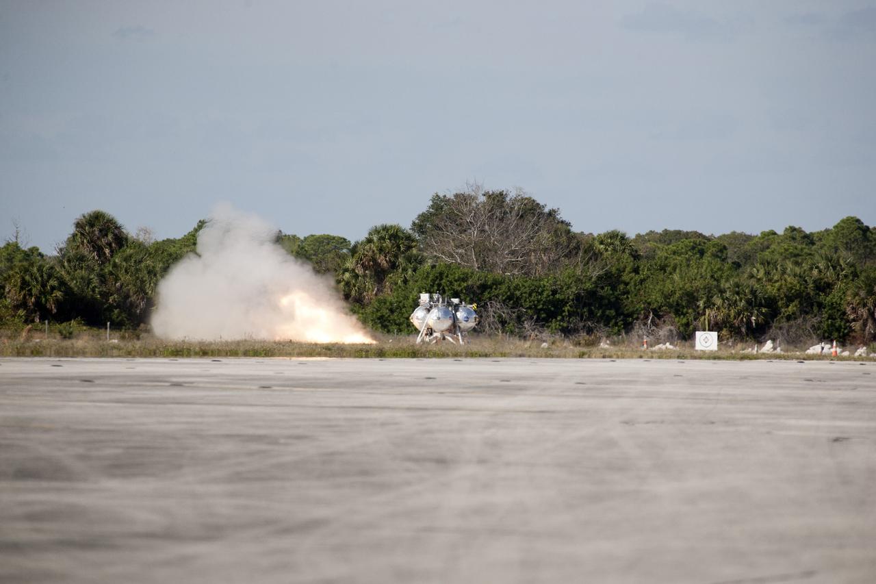 CAPE CANAVERAL, Fla. – The first free flight of the Project Morpheus prototype lander begins as the lander’s engine fires at the north of the Shuttle Landing Facility at NASA’s Kennedy Space Center in Florida. Testing of the prototype lander was performed at NASA’s Johnson Space Center in Houston in preparation for tethered and free flight testing at Kennedy. Project Morpheus integrates NASA’s automated landing and hazard avoidance technology, or ALHAT, with an engine that runs on liquid oxygen and methane, or green propellants, into a fully-operational lander that could deliver cargo to asteroids and other planetary surfaces.    The landing facility will provide the lander with the kind of field necessary for realistic testing, complete with rocks, craters and hazards to avoid. Morpheus’ ALHAT payload allows it to navigate to clear landing sites amidst rocks, craters and other hazards during its descent. Project Morpheus is being managed under the Advanced Exploration Systems, or AES, Division in NASA’s Human Exploration and Operations Mission Directorate. The efforts in AES pioneer new approaches for rapidly developing prototype systems, demonstrating key capabilities and validating operational concepts for future human missions beyond Earth orbit. For more information on Project Morpheus, visit http://morpheuslander.jsc.nasa.gov.  Photo credit: NASA/Kim Shiflett