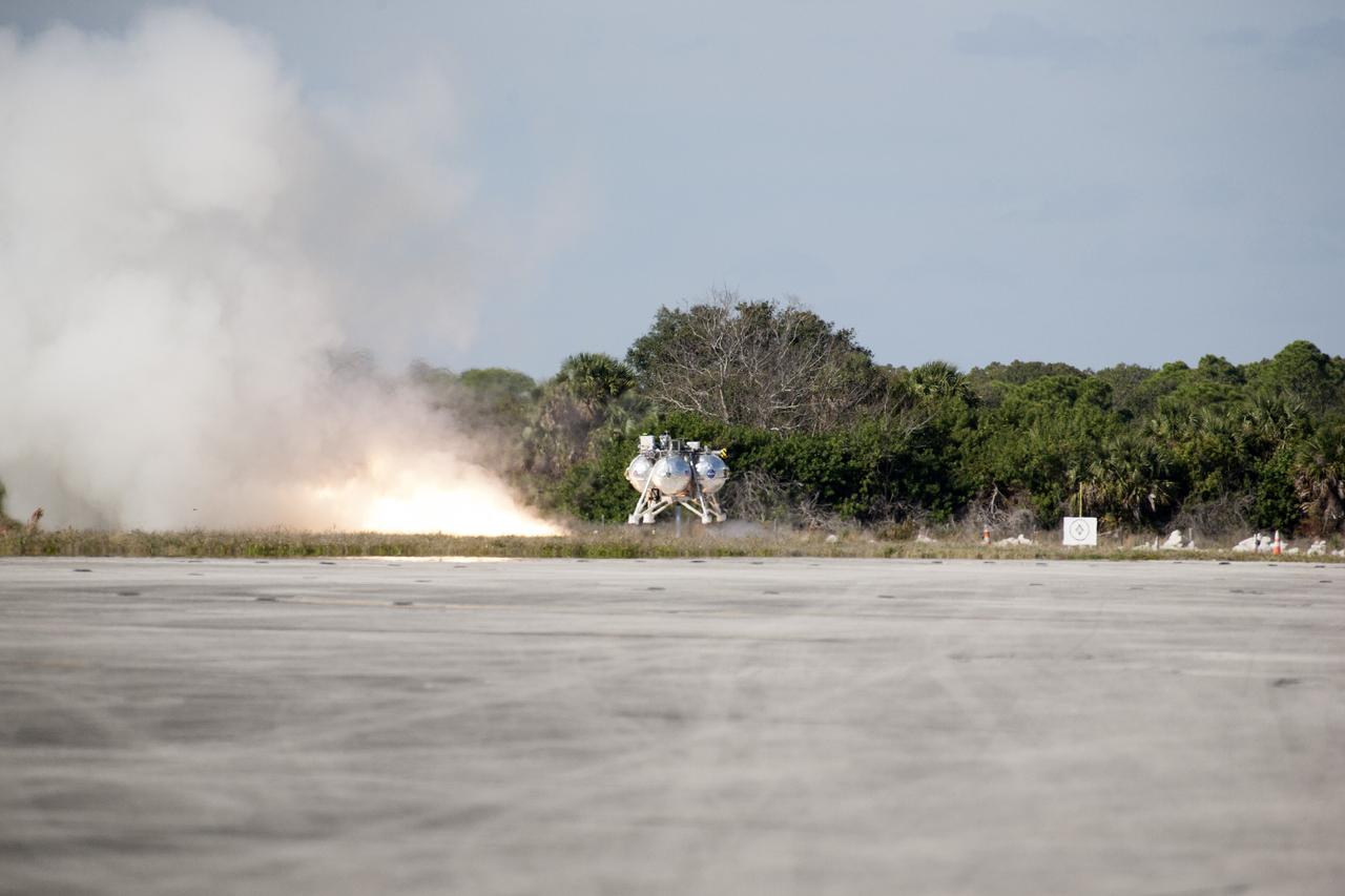 CAPE CANAVERAL, Fla. – The first free flight of the Project Morpheus prototype lander begins as the lander’s engine fires at the north of the Shuttle Landing Facility at NASA’s Kennedy Space Center in Florida. Testing of the prototype lander was performed at NASA’s Johnson Space Center in Houston in preparation for tethered and free flight testing at Kennedy. Project Morpheus integrates NASA’s automated landing and hazard avoidance technology, or ALHAT, with an engine that runs on liquid oxygen and methane, or green propellants, into a fully-operational lander that could deliver cargo to asteroids and other planetary surfaces.    The landing facility will provide the lander with the kind of field necessary for realistic testing, complete with rocks, craters and hazards to avoid. Morpheus’ ALHAT payload allows it to navigate to clear landing sites amidst rocks, craters and other hazards during its descent. Project Morpheus is being managed under the Advanced Exploration Systems, or AES, Division in NASA’s Human Exploration and Operations Mission Directorate. The efforts in AES pioneer new approaches for rapidly developing prototype systems, demonstrating key capabilities and validating operational concepts for future human missions beyond Earth orbit. For more information on Project Morpheus, visit http://morpheuslander.jsc.nasa.gov.  Photo credit: NASA/Kim Shiflett