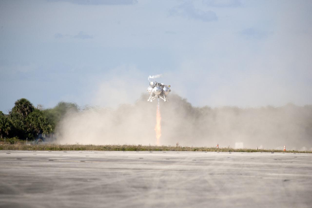 CAPE CANAVERAL, Fla. – The first free flight of the Project Morpheus prototype lander was conducted at the Shuttle Landing Facility at NASA’s Kennedy Space Center in Florida. Smoke filled the air as the engine fired and the Morpheus lander launched from the ground over a flame trench. During the 54-second test, it ascended approximately 50 feet, and hovered for about 15 seconds. The lander then flew forward and landed on its pad about 23 feet from the launch point. Testing of the prototype lander was performed at NASA’s Johnson Space Center in Houston in preparation for tethered and free flight testing at Kennedy. Project Morpheus integrates NASA’s automated landing and hazard avoidance technology, or ALHAT, with an engine that runs on liquid oxygen and methane, or green propellants, into a fully-operational lander that could deliver cargo to asteroids and other planetary surfaces.    The landing facility will provide the lander with the kind of field necessary for realistic testing, complete with rocks, craters and hazards to avoid. Morpheus’ ALHAT payload allows it to navigate to clear landing sites amidst rocks, craters and other hazards during its descent. Project Morpheus is being managed under the Advanced Exploration Systems, or AES, Division in NASA’s Human Exploration and Operations Mission Directorate. The efforts in AES pioneer new approaches for rapidly developing prototype systems, demonstrating key capabilities and validating operational concepts for future human missions beyond Earth orbit. For more information on Project Morpheus, visit http://morpheuslander.jsc.nasa.gov.  Photo credit: NASA/Kim Shiflett