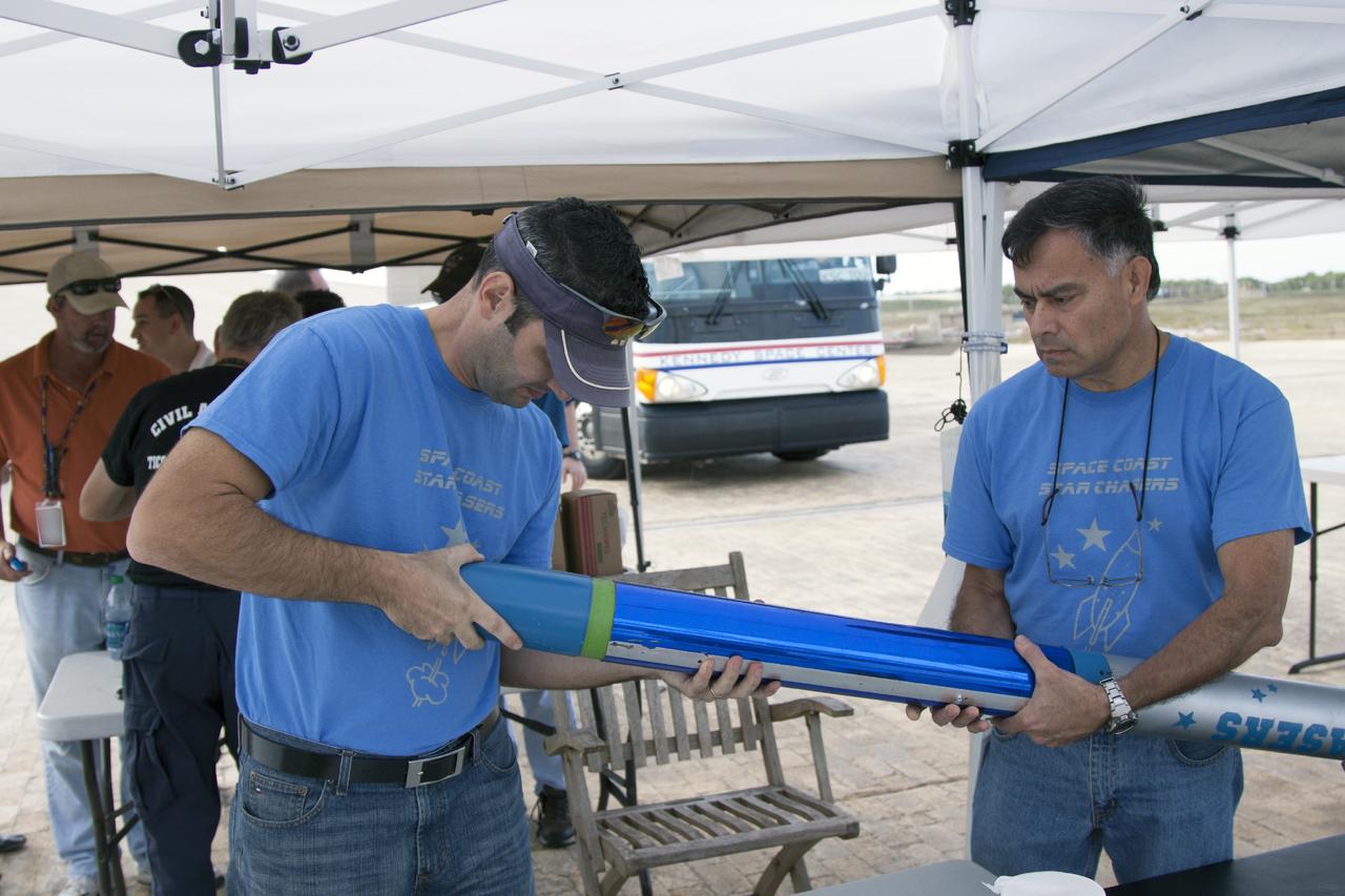 CAPE CANAVERAL, Fla. -- At NASA's Kennedy Space Center in Florida, from the left, Leandro James, rocket avionics lead, and Julio Najarro of Mechanical Systems make final adjustments to a small rocket prior to launch as part of Rocket University. The launch will test systems designed by the student engineers.      As part of Rocket University, the engineers are given an opportunity to work a fast-track project to develop skills in developing spacecraft systems of the future. As NASA plans for future spaceflight programs to low-Earth orbit and beyond, teams of engineers at Kennedy are gaining experience in designing and flying launch vehicle systems on a small scale. Four teams of five to eight members from Kennedy are designing rockets complete with avionics and recovery systems. Launch operations require coordination with federal agencies, just as they would with rockets launched in support of a NASA mission. Photo credit: NASA/Jim Grossmann
