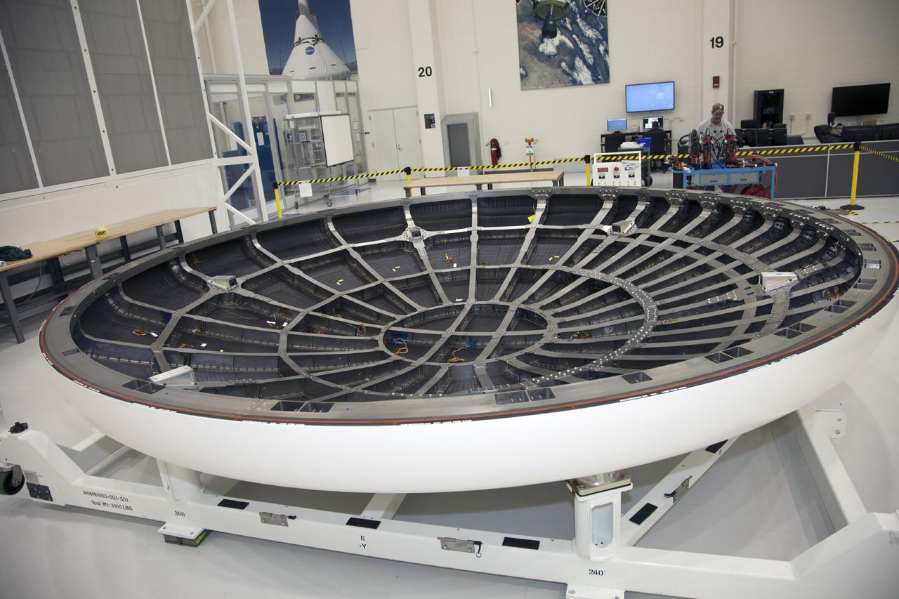 CAPE CANAVERAL, Fla. -- The heat shield for the Orion spacecraft has been placed on a work stand inside the Operations and Checkout Building high bay at NASA’s Kennedy Space Center in Florida. The heat shield arrived at Kennedy’s Shuttle Landing Facility on Dec. 5 on NASA’s Super Guppy aircraft. The largest of its kind ever built, the heat shield is planned for installation on the Orion crew module in March 2014.    The Orion spacecraft is being prepared for its first unpiloted flight test, Exploration Flight Test-1, or EFT-1, scheduled for launch atop a Delta IV rocket in September 2014. The Orion spacecraft is designed to carry astronauts to destinations not yet explored by humans. It will have emergency abort capability, sustain the crew during space travel and provide safe re-entry from deep space return velocities. Orion is scheduled to launch atop NASA’s Space Launch System rocket in 2017. For more information, visit http://www.nasa.gov/orion. Photo credit: NASA/Mike Chambers