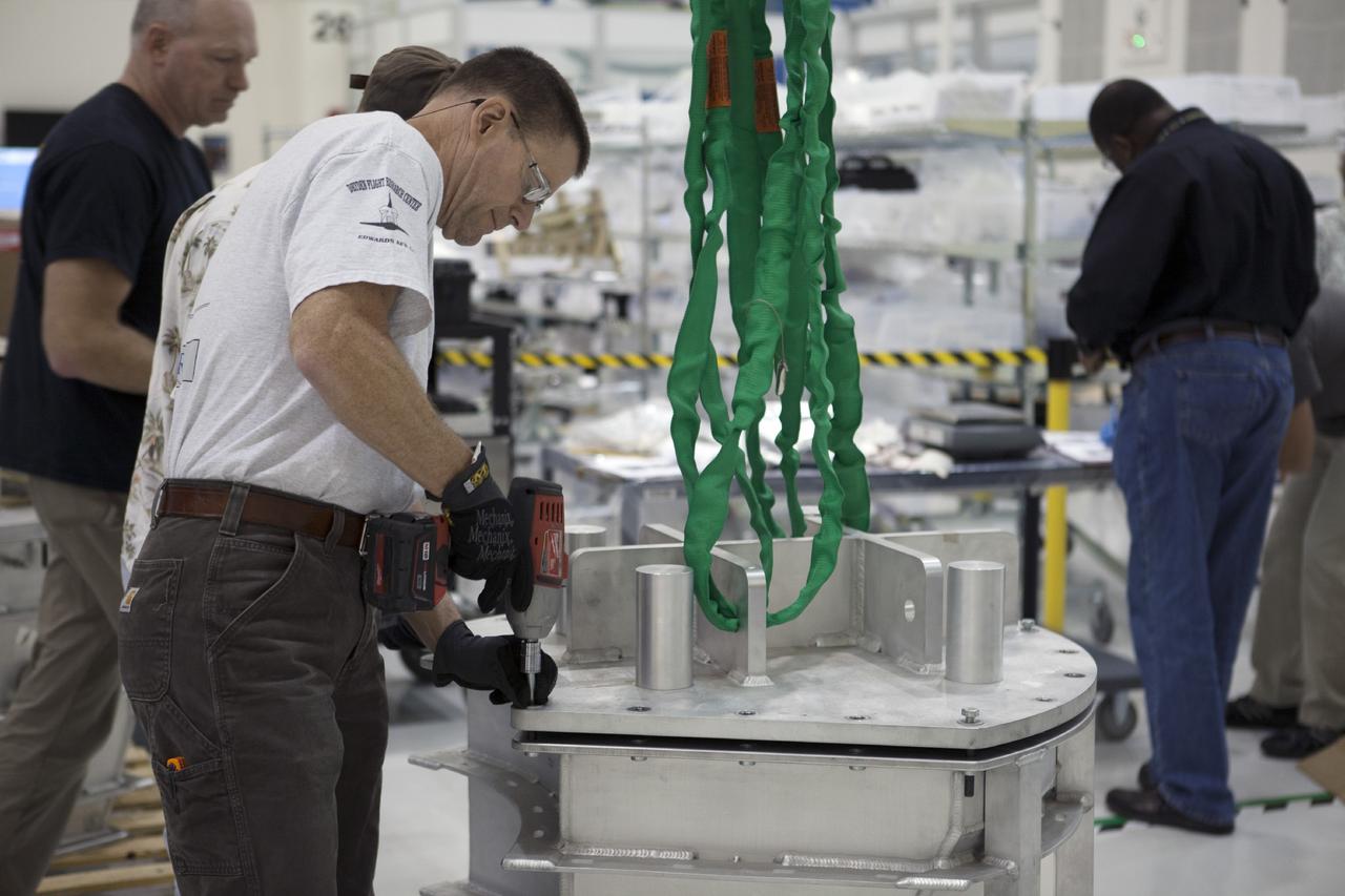CAPE CANAVERAL, Fla. -- Inside the Operations and Checkout Building high bay at NASA’s Kennedy Space Center in Florida, a technician removes the cover from a shipping container that carries one of the three main parachutes for the Orion spacecraft. The parachute will be prepared for installation on Orion.     The Orion spacecraft is being prepared for its first unpiloted flight test, Exploration Flight Test-1, or EFT-1, scheduled for launch atop a Delta IV rocket in September 2014. The Orion spacecraft is designed to carry astronauts to destinations not yet explored by humans. It will have emergency abort capability, sustain the crew during space travel and provide safe re-entry from deep space return velocities. Orion is scheduled to launch atop NASA’s Space Launch System rocket in 2017. For more information, visit http://www.nasa.gov/orion. Photo credit: NASA/Kim Shiflett