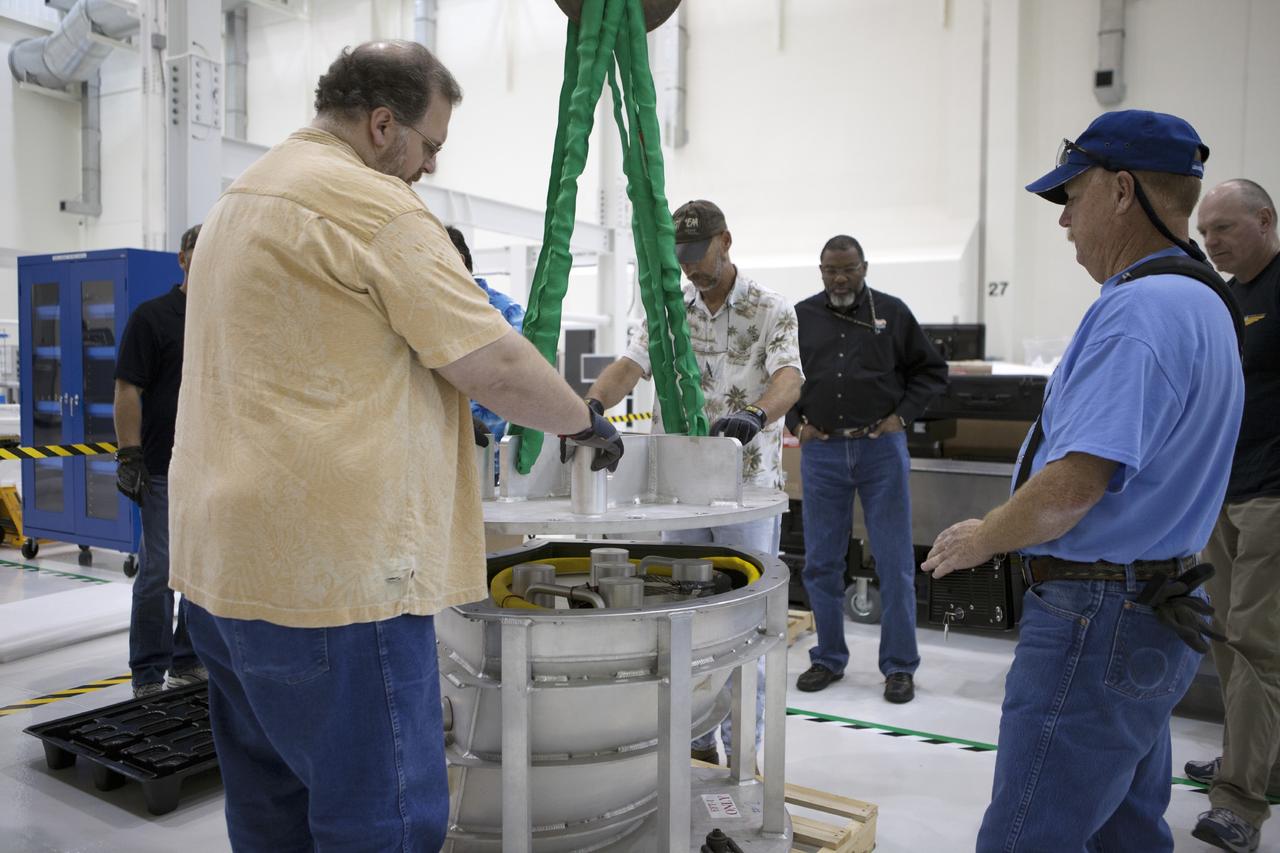 CAPE CANAVERAL, Fla. -- Inside the Operations and Checkout Building high bay at NASA’s Kennedy Space Center in Florida, technicians remove the cover from a shipping container that carries one of the three main parachutes for the Orion spacecraft. The parachute will be prepared for installation on Orion.     The Orion spacecraft is being prepared for its first unpiloted flight test, Exploration Flight Test-1, or EFT-1, scheduled for launch atop a Delta IV rocket in September 2014. The Orion spacecraft is designed to carry astronauts to destinations not yet explored by humans. It will have emergency abort capability, sustain the crew during space travel and provide safe re-entry from deep space return velocities. Orion is scheduled to launch atop NASA’s Space Launch System rocket in 2017. For more information, visit http://www.nasa.gov/orion. Photo credit: NASA/Kim Shiflett