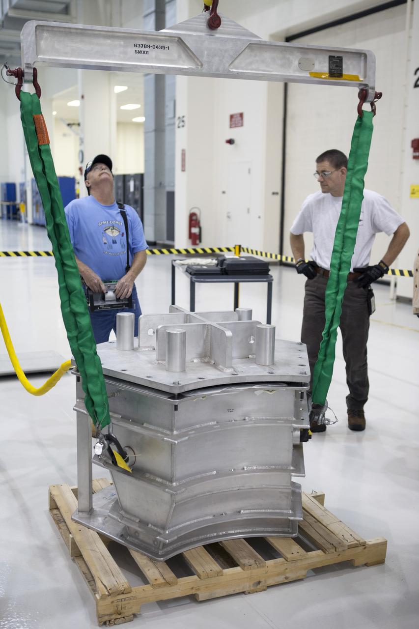 CAPE CANAVERAL, Fla. -- Inside the Operations and Checkout Building high bay at NASA’s Kennedy Space Center in Florida, a crane is used to lift the cover off of a shipping container that carries one of three main parachutes for the Orion spacecraft. The parachute will be prepared for installation on Orion.     The Orion spacecraft is being prepared for its first unpiloted flight test, Exploration Flight Test-1, or EFT-1, scheduled for launch atop a Delta IV rocket in September 2014. The Orion spacecraft is designed to carry astronauts to destinations not yet explored by humans. It will have emergency abort capability, sustain the crew during space travel and provide safe re-entry from deep space return velocities. Orion is scheduled to launch atop NASA’s Space Launch System rocket in 2017. For more information, visit http://www.nasa.gov/orion. Photo credit: NASA/Kim Shiflett