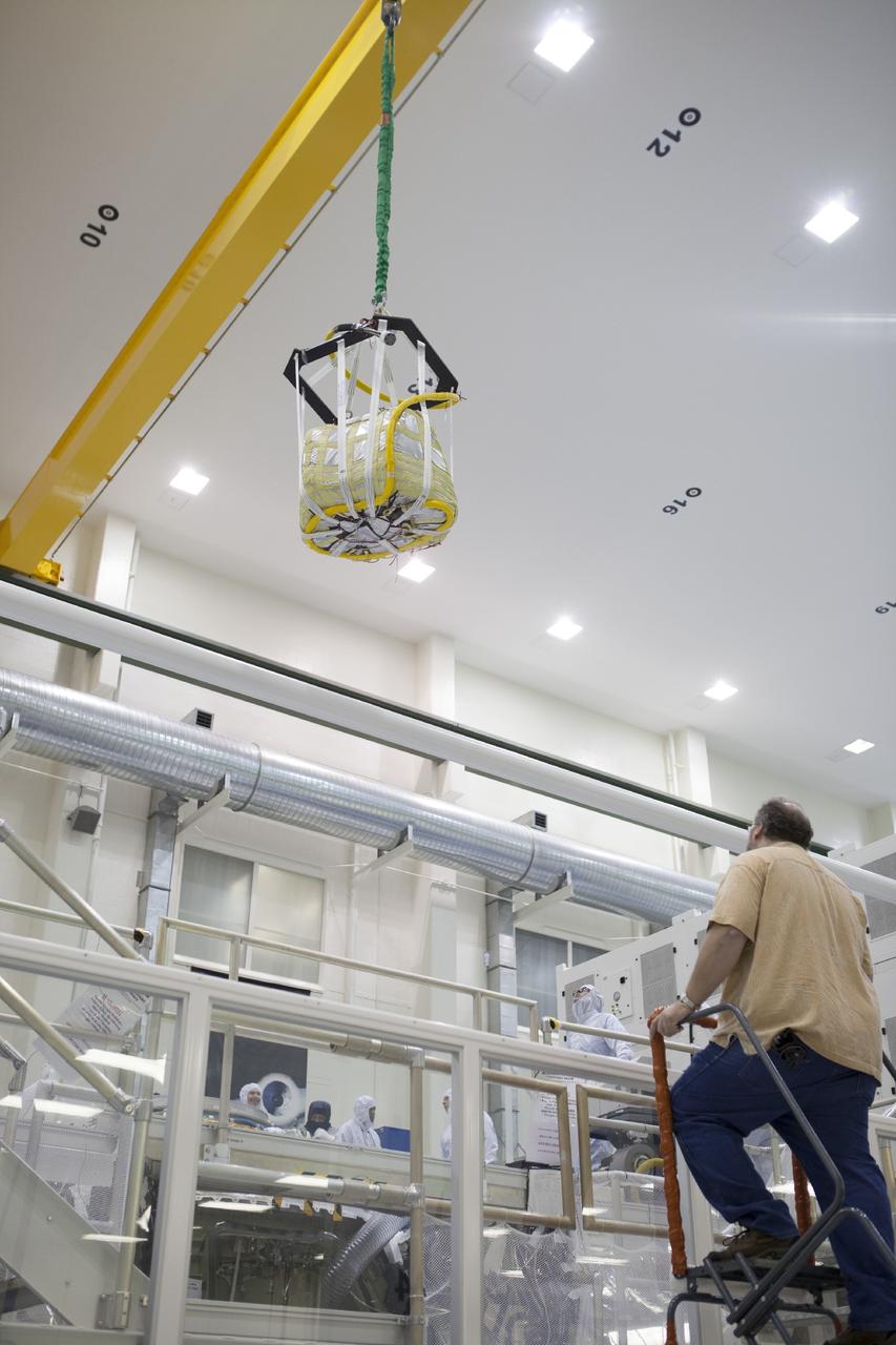 CAPE CANAVERAL, Fla. -- A crane moves one of three main parachutes for the Orion spacecraft inside the Operations and Checkout Building high bay at NASA’s Kennedy Space Center in Florida. The parachute is being prepared for installation on Orion.     The Orion spacecraft is being prepared for its first unpiloted flight test, Exploration Flight Test-1, or EFT-1, scheduled for launch atop a Delta IV rocket in September 2014. The Orion spacecraft is designed to carry astronauts to destinations not yet explored by humans. It will have emergency abort capability, sustain the crew during space travel and provide safe re-entry from deep space return velocities. Orion is scheduled to launch atop NASA’s Space Launch System rocket in 2017. For more information, visit http://www.nasa.gov/orion. Photo credit: NASA/Kim Shiflett