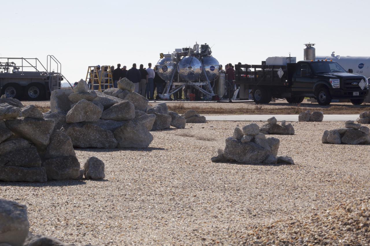 CAPE CANAVERAL, Fla. -- Preparations are underway to prepare the Project Morpheus prototype lander for a second free flight test at the north end of the Shuttle Landing Facility at NASA’s Kennedy Space Center in Florida. Testing of the prototype lander was performed at NASA’s Johnson Space Center in Houston in preparation for tethered and free flight testing at Kennedy. Project Morpheus integrates NASA’s automated landing and hazard avoidance technology, or ALHAT, with an engine that runs on liquid oxygen and methane, or green propellants, into a fully-operational lander that could deliver cargo to other planetary surfaces.    The landing facility will provide the lander with the kind of field necessary for realistic testing, complete with rocks, craters and hazards to avoid. Morpheus’ ALHAT payload allows it to navigate to clear landing sites amidst rocks, craters and other hazards during its descent. Project Morpheus is being managed under the Advanced Exploration Systems, or AES, Division in NASA’s Human Exploration and Operations Mission Directorate. The efforts in AES pioneer new approaches for rapidly developing prototype systems, demonstrating key capabilities and validating operational concepts for future human missions beyond Earth orbit. For more information on Project Morpheus, visit http://morpheuslander.jsc.nasa.gov.  Photo credit: NASA/Dimitri Gerondidakis