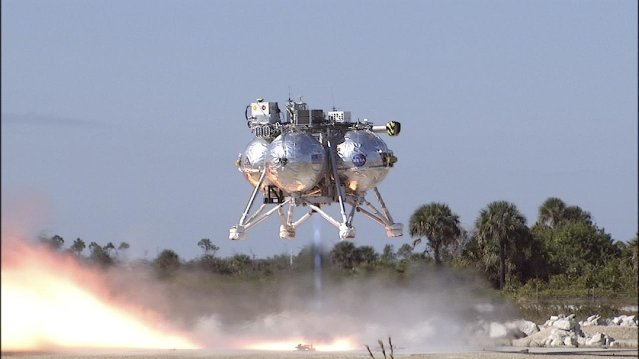 CAPE CANAVERAL, Fla. -- The second free flight of the Project Morpheus prototype lander was conducted at the north end of the Shuttle Landing Facility at NASA’s Kennedy Space Center in Florida. The 81-second test began at 1:37 p.m. EST with the Morpheus lander launching from the ground over a flame trench and ascending about 164 feet, pausing briefly at 82 feet. The lander flew forward, covering about 154 feet in 30 seconds before descending and landing on a dedicated landing pad inside the autonomous landing and hazard avoidance technology, or ALHAT, hazard field. Project Morpheus tests NASA’s ALHAT and an engine that runs on liquid oxygen and methane, or green propellants, into a fully-operational lander that could deliver cargo to other planetary surfaces.     The landing facility provides the lander with the kind of field necessary for realistic testing, complete with rocks, craters and hazards to avoid. Morpheus’ ALHAT payload allows it to navigate to clear landing sites amidst rocks, craters and other hazards during its descent. Project Morpheus is being managed under the Advanced Exploration Systems, or AES, Division in NASA’s Human Exploration and Operations Mission Directorate. The efforts in AES pioneer new approaches for rapidly developing prototype systems, demonstrating key capabilities and validating operational concepts for future human missions beyond Earth orbit. For more information on Project Morpheus, visit http://www.nasa.gov/centers/johnson/exploration/morpheus.  Photo credit: NASA/Chris Chamberland