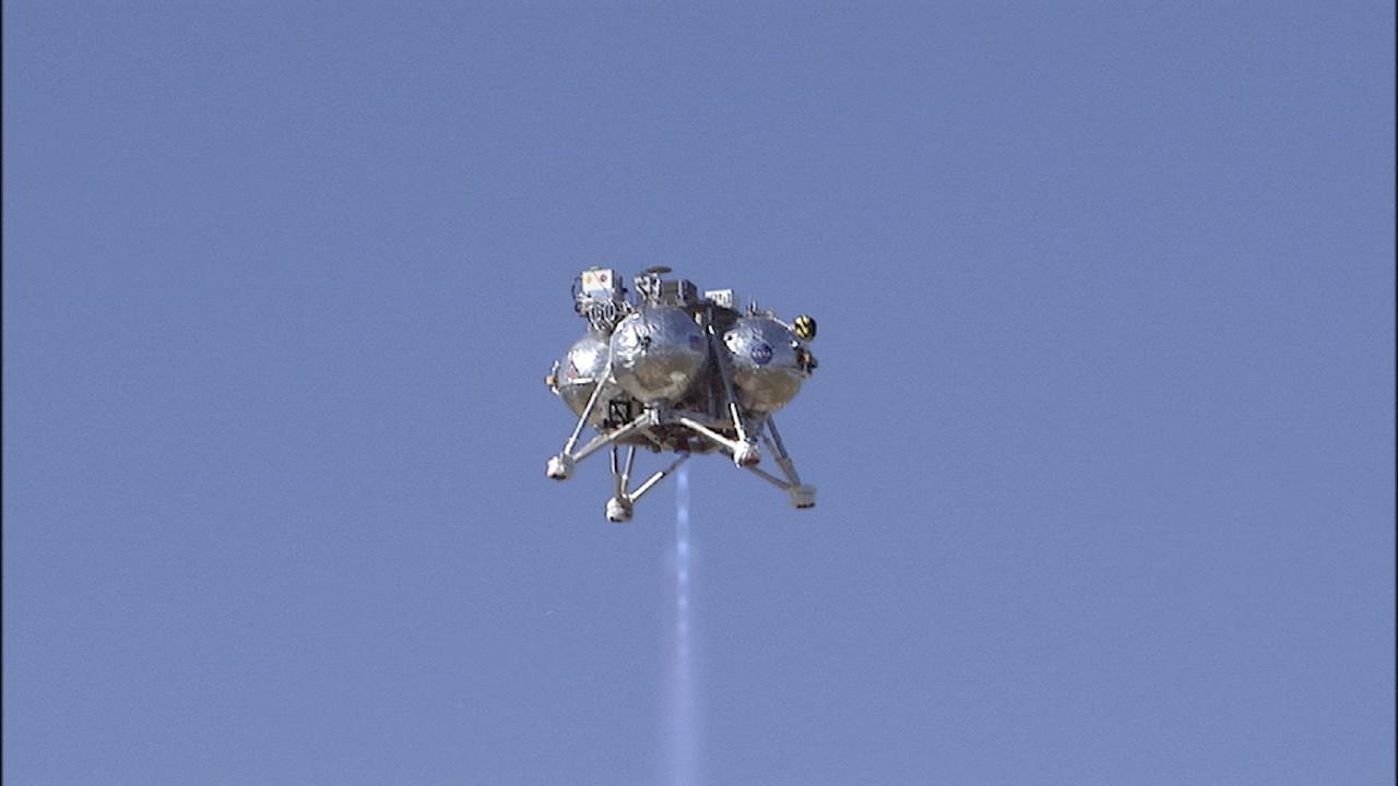 CAPE CANAVERAL, Fla. -- The second free flight of the Project Morpheus prototype lander was conducted at the north end of the Shuttle Landing Facility at NASA’s Kennedy Space Center in Florida. The 81-second test began at 1:37 p.m. EST with the Morpheus lander launching from the ground over a flame trench and ascending about 164 feet, pausing briefly at 82 feet. The lander flew forward, covering about 154 feet in 30 seconds before descending and landing on a dedicated landing pad inside the autonomous landing and hazard avoidance technology, or ALHAT, hazard field. Project Morpheus tests NASA’s ALHAT and an engine that runs on liquid oxygen and methane, or green propellants, into a fully-operational lander that could deliver cargo to other planetary surfaces.     The landing facility provides the lander with the kind of field necessary for realistic testing, complete with rocks, craters and hazards to avoid. Morpheus’ ALHAT payload allows it to navigate to clear landing sites amidst rocks, craters and other hazards during its descent. Project Morpheus is being managed under the Advanced Exploration Systems, or AES, Division in NASA’s Human Exploration and Operations Mission Directorate. The efforts in AES pioneer new approaches for rapidly developing prototype systems, demonstrating key capabilities and validating operational concepts for future human missions beyond Earth orbit. For more information on Project Morpheus, visit http://www.nasa.gov/centers/johnson/exploration/morpheus.  Photo credit: NASA/Chris Chamberland