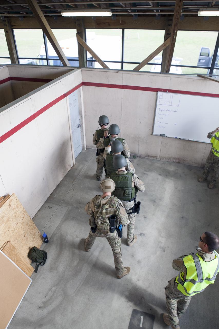 CAPE CANAVERAL, Fla. – At NASA’s Protective Services Training Academy at Kennedy Space Center in Florida, members of the Emergency Response Team, or ERT, participate in specialized training simulations in order to keep their skills current. They are wearing full protective gear and carrying non-lethal firearms, which are denoted in blue, for the training exercises.    Recently, eight members of the ERT competed in the 31st Annual SWAT Roundup International competition in Orlando, Fla., and received recognition by placing in the top five overall.  In keeping with NASA’s commitment to safety and security of workforce and assets, the ERT is part of Kennedy’s security team and is trained to respond in the event of an emergency at the center.  Photo credit: NASA/Dimitri Gerondidakis