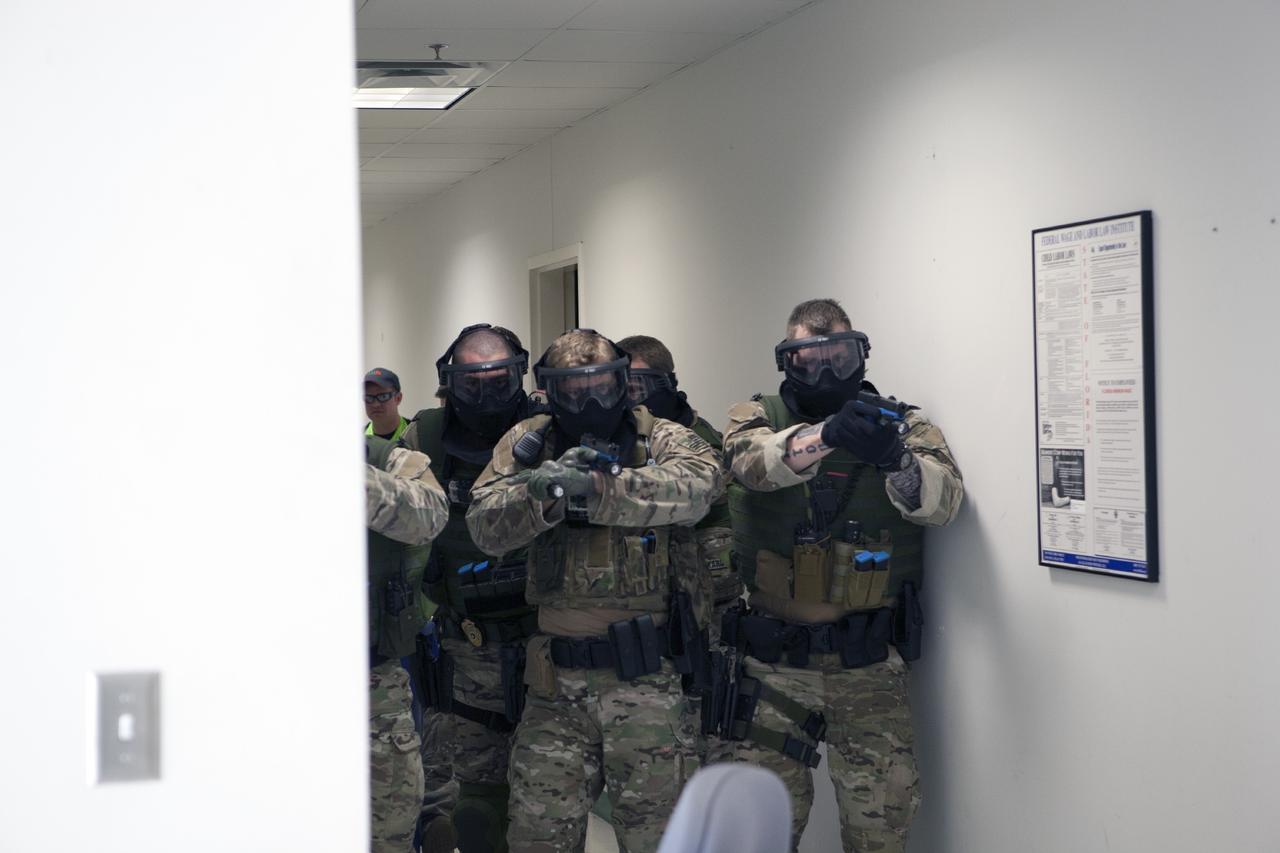 CAPE CANAVERAL, Fla. – At a training location near Launch Complex 39 at NASA’s Kennedy Space Center in Florida, members of the Emergency Response Team, or ERT, participate in specialized training simulations in order to keep their skills current. They are wearing full protective gear and carrying non-lethal firearms, which are denoted in blue, for the training exercises.    Recently, eight members of the ERT competed in the 31st Annual SWAT Roundup International competition in Orlando, Fla., and received recognition by placing in the top five overall.  In keeping with NASA’s commitment to safety and security of workforce and assets, the ERT is part of Kennedy’s security team and is trained to respond in the event of an emergency at the center.  Photo credit: NASA/Daniel Casper
