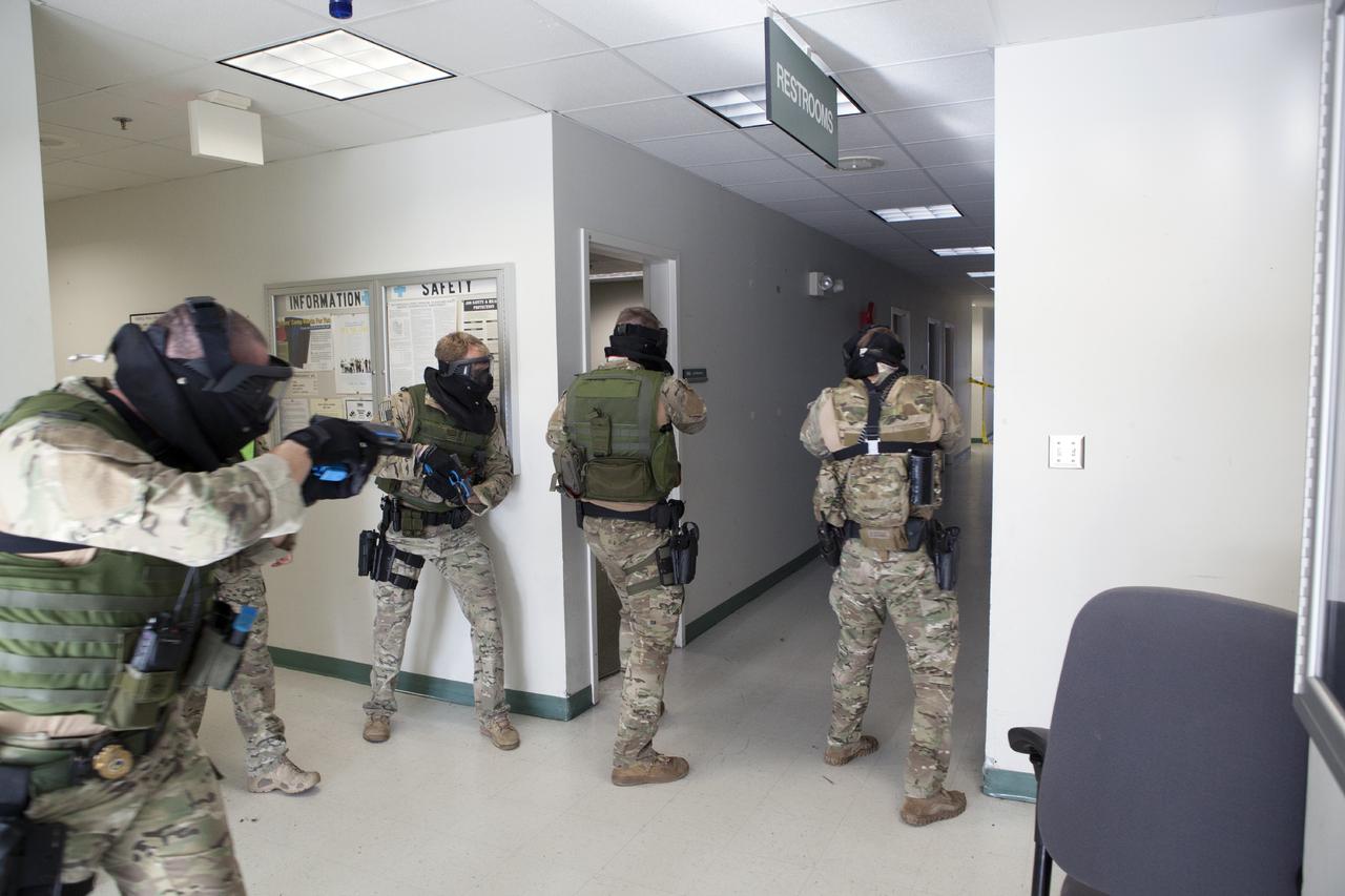 CAPE CANAVERAL, Fla. – At a training location near Launch Complex 39 at NASA’s Kennedy Space Center in Florida, members of the Emergency Response Team, or ERT, participate in specialized training simulations in order to keep their skills current. They are wearing full protective gear and carrying non-lethal firearms, which are denoted in blue, for the training exercises.    Recently, eight members of the ERT competed in the 31st Annual SWAT Roundup International competition in Orlando, Fla., and received recognition by placing in the top five overall.  In keeping with NASA’s commitment to safety and security of workforce and assets, the ERT is part of Kennedy’s security team and is trained to respond in the event of an emergency at the center.  Photo credit: NASA/Daniel Casper
