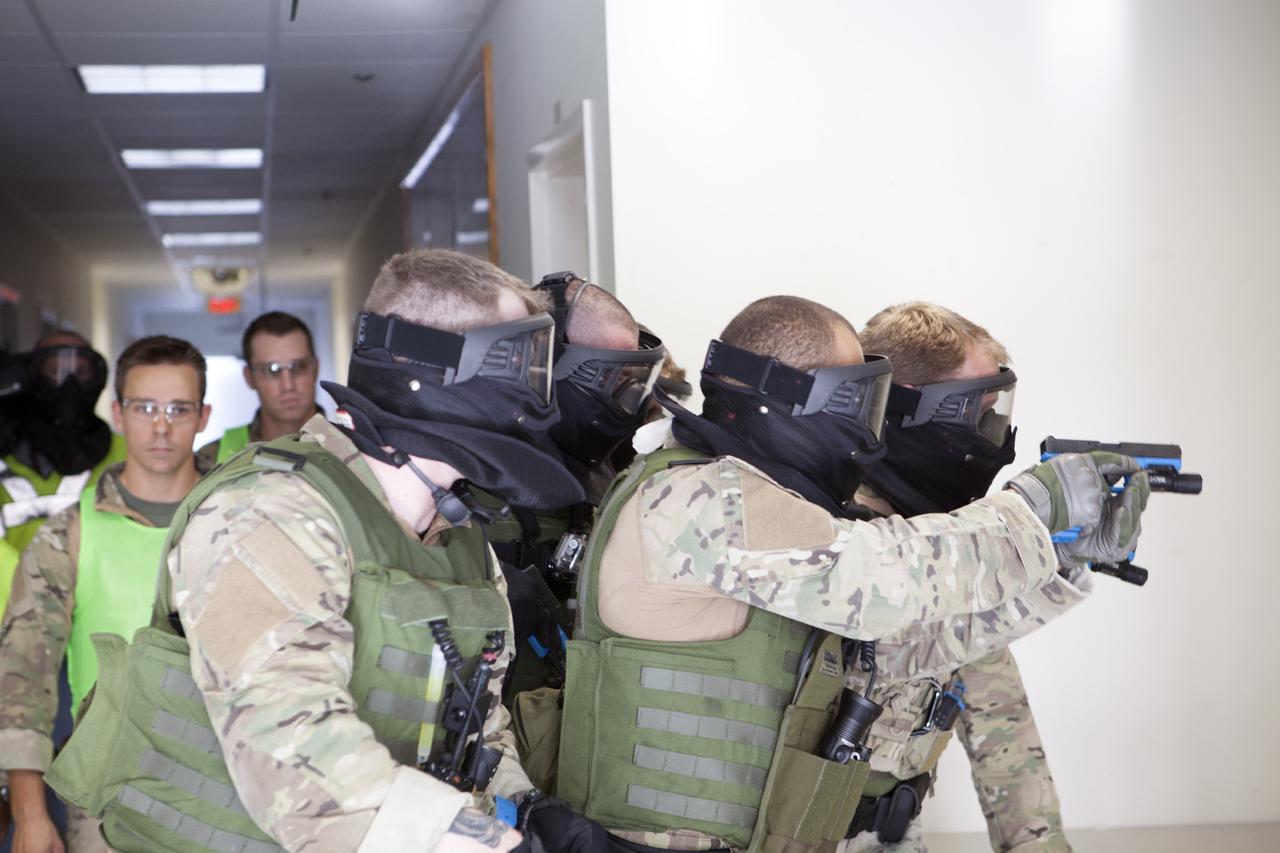 CAPE CANAVERAL, Fla. – At a training location near Launch Complex 39 at NASA’s Kennedy Space Center in Florida, members of the Emergency Response Team, or ERT, participate in specialized training simulations in order to keep their skills current. They are wearing full protective gear and carrying non-lethal firearms, which are denoted in blue, for the training exercises. In the background, the ERT training supervisor, wearing a bright green vest, monitors the training exercise and reviews procedures.    Recently, eight members of the ERT competed in the 31st Annual SWAT Roundup International competition in Orlando, Fla., and received recognition by placing in the top five overall.  In keeping with NASA’s commitment to safety and security of workforce and assets, the ERT is part of Kennedy’s security team and is trained to respond in the event of an emergency at the center.  Photo credit: NASA/Daniel Casper