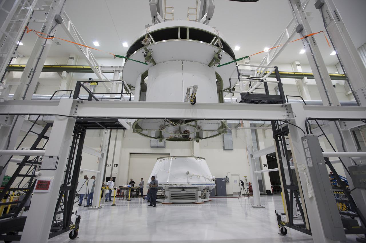 CAPE CANAVERAL, Fla. – Inside the Operations and Checkout Building at NASA’s Kennedy Space Center in Florida, workers are preparing to move the spacecraft adapter cone for the Orion vehicle closer to the service module which is suspended above the floor by a movable crane. Orion is the exploration spacecraft designed to carry astronauts to destinations not yet explored by humans, including an asteroid and Mars. It will have emergency abort capability, sustain the crew during space travel and provide safe re-entry from deep space return velocities. The first unpiloted test flight of the Orion is scheduled to launch in 2014 atop a Delta IV rocket and in 2017 on NASA’s Space Launch System rocket. For more information, visit http://www.nasa.gov/orion. Photo credit: NASA/Kim Shiflett