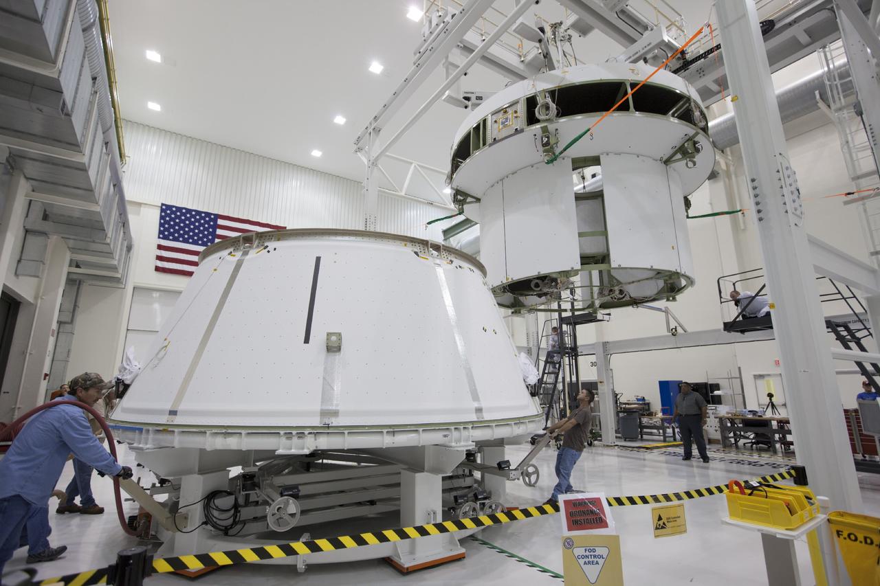 CAPE CANAVERAL, Fla. – Inside the Operations and Checkout Building at NASA’s Kennedy Space Center in Florida, workers move the spacecraft adapter cone for Orion closer to the service module for Orion, which is suspended above the floor by a movable crane. Orion is the exploration spacecraft designed to carry astronauts to destinations not yet explored by humans, including an asteroid and Mars. It will have emergency abort capability, sustain the crew during space travel and provide safe re-entry from deep space return velocities. The first unpiloted test flight of the Orion is scheduled to launch in 2014 atop a Delta IV rocket and in 2017 on NASA’s Space Launch System rocket. For more information, visit http://www.nasa.gov/orion. Photo credit: NASA/Kim Shiflett
