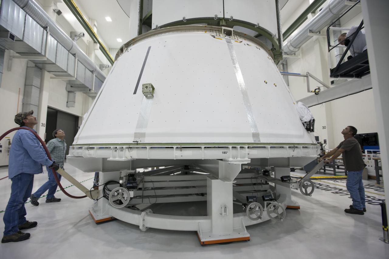 CAPE CANAVERAL, Fla. – Inside the Operations and Checkout Building at NASA’s Kennedy Space Center in Florida, workers move the spacecraft adapter cone for Orion underneath the service module, which is suspended above the floor by a movable crane. Orion is the exploration spacecraft designed to carry astronauts to destinations not yet explored by humans, including an asteroid and Mars. It will have emergency abort capability, sustain the crew during space travel and provide safe re-entry from deep space return velocities. The first unpiloted test flight of the Orion is scheduled to launch in 2014 atop a Delta IV rocket and in 2017 on NASA’s Space Launch System rocket. For more information, visit http://www.nasa.gov/orion. Photo credit: NASA/Kim Shiflett