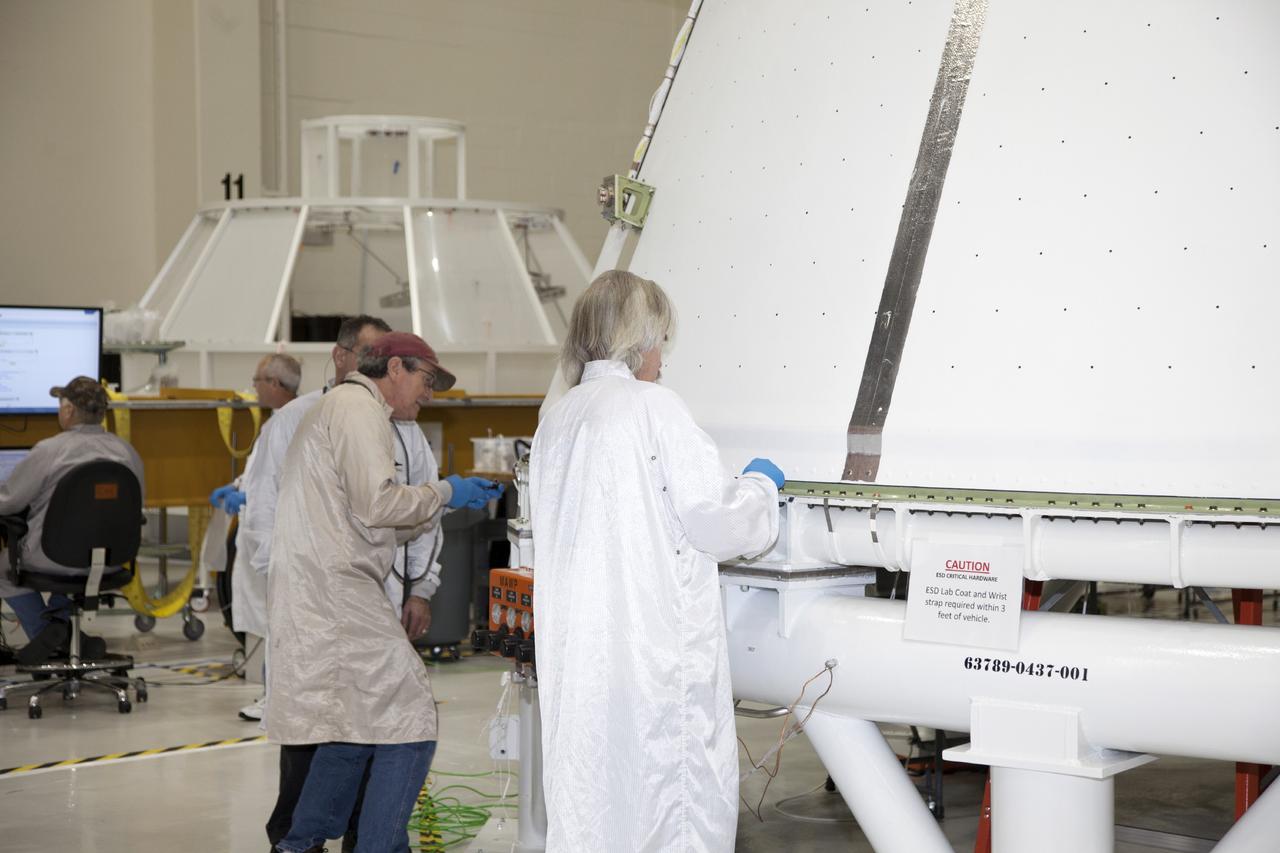 CAPE CANAVERAL, Fla. – Inside the Operations and Checkout Building high bay at NASA’s Kennedy Space Center in Florida, technicians prepare the first of three fairings for installation on the service module for the Orion spacecraft. The Orion spacecraft is being prepared for its first unpiloted flight test, Exploration Flight Test-1, or EFT-1, scheduled for launch atop a Delta IV rocket in September 2014. The Orion spacecraft is designed to carry astronauts to destinations not yet explored by humans. It will have emergency abort capability, sustain the crew during space travel and provide safe re-entry from deep space return velocities. Orion is scheduled to launch atop NASA’s Space Launch System rocket in 2017. For more information, visit http://www.nasa.gov/orion. Photo credit: NASA/Daniel Casper