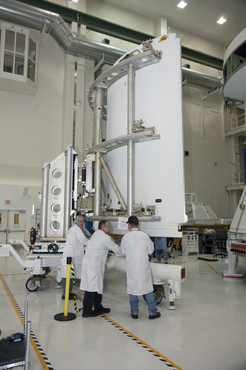 CAPE CANAVERAL, Fla. – Inside the Operations and Checkout Building high bay at NASA’s Kennedy Space Center in Florida, technicians use a special handling device to move the first of three fairings for installation on the service module for the Orion spacecraft. The Orion spacecraft is being prepared for its first unpiloted flight test, Exploration Flight Test-1, or EFT-1, scheduled for launch atop a Delta IV rocket in September 2014. The Orion spacecraft is designed to carry astronauts to destinations not yet explored by humans. It will have emergency abort capability, sustain the crew during space travel and provide safe re-entry from deep space return velocities. Orion is scheduled to launch atop NASA’s Space Launch System rocket in 2017. For more information, visit http://www.nasa.gov/orion. Photo credit: NASA/Daniel Casper