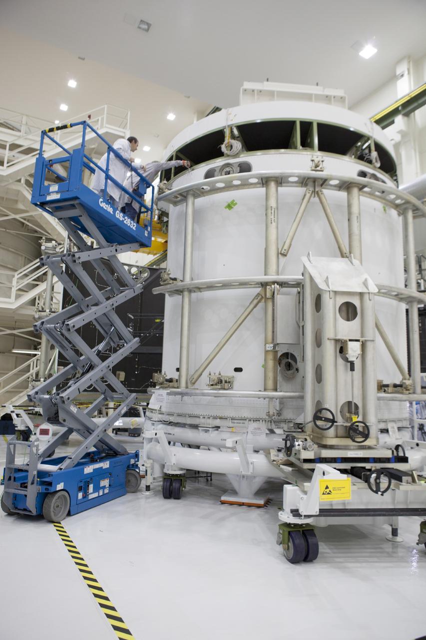 CAPE CANAVERAL, Fla. – Inside the Operations and Checkout Building high bay at NASA’s Kennedy Space Center in Florida, technicians on a scissor lift monitor the progress as a special handling device is used to move the second of three fairings closer for installation on the service module for the Orion spacecraft. The Orion spacecraft is being prepared for its first unpiloted flight test, Exploration Flight Test-1, or EFT-1, scheduled for launch atop a Delta IV rocket in September 2014. The Orion spacecraft is designed to carry astronauts to destinations not yet explored by humans. It will have emergency abort capability, sustain the crew during space travel and provide safe re-entry from deep space return velocities. Orion is scheduled to launch atop NASA’s Space Launch System rocket in 2017. For more information, visit http://www.nasa.gov/orion. Photo credit: NASA/Dimitri Gerondidakis