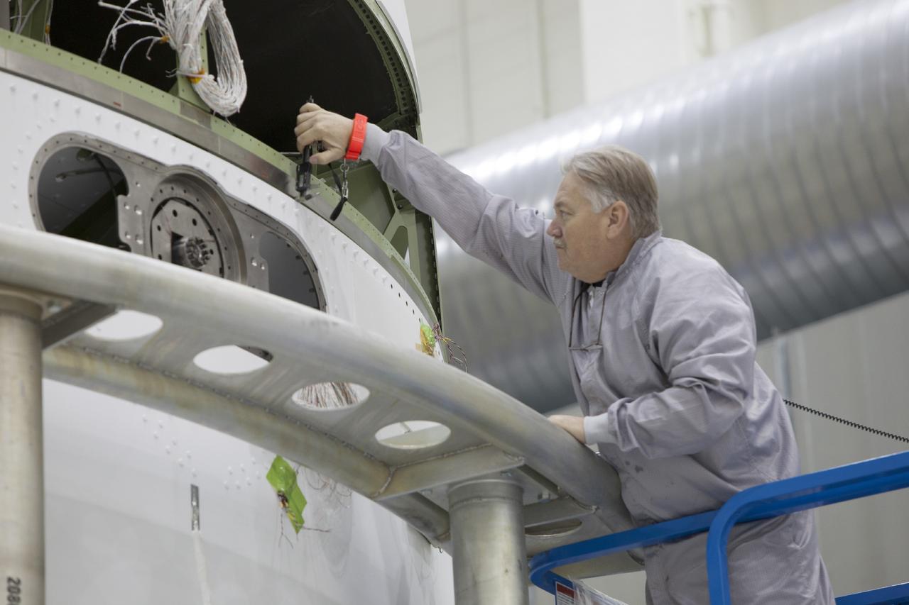 CAPE CANAVERAL, Fla. – Inside the Operations and Checkout Building high bay at NASA’s Kennedy Space Center in Florida, a technician on a scissor lift works on the installation of the second of three fairings on the service module for the Orion spacecraft. The Orion spacecraft is being prepared for its first unpiloted flight test, Exploration Flight Test-1, or EFT-1, scheduled for launch atop a Delta IV rocket in September 2014. The Orion spacecraft is designed to carry astronauts to destinations not yet explored by humans. It will have emergency abort capability, sustain the crew during space travel and provide safe re-entry from deep space return velocities. Orion is scheduled to launch atop NASA’s Space Launch System rocket in 2017. For more information, visit http://www.nasa.gov/orion. Photo credit: NASA/Dimitri Gerondidakis