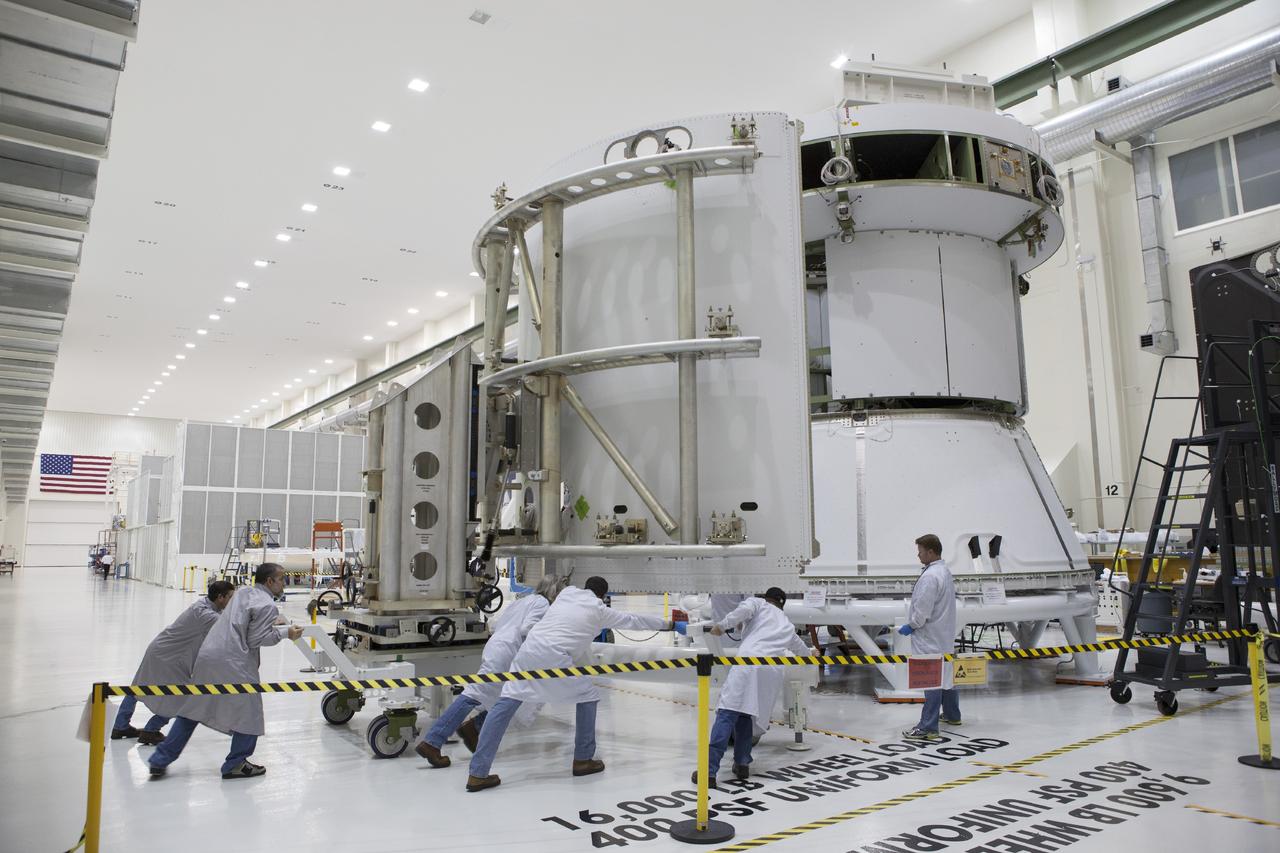 CAPE CANAVERAL, Fla. – Inside the Operations and Checkout Building high bay at NASA’s Kennedy Space Center in Florida, technicians use a special handling device to move the second of three fairings closer for installation on the service module for the Orion spacecraft. The Orion spacecraft is being prepared for its first unpiloted flight test, Exploration Flight Test-1, or EFT-1, scheduled for launch atop a Delta IV rocket in September 2014. The Orion spacecraft is designed to carry astronauts to destinations not yet explored by humans. It will have emergency abort capability, sustain the crew during space travel and provide safe re-entry from deep space return velocities. Orion is scheduled to launch atop NASA’s Space Launch System rocket in 2017. For more information, visit http://www.nasa.gov/orion. Photo credit: NASA/Dimitri Gerondidakis