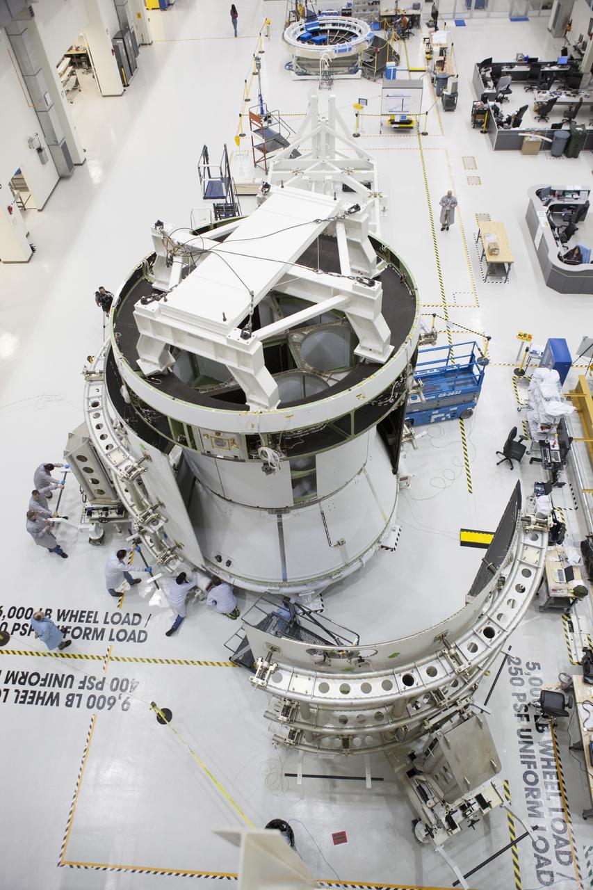 CAPE CANAVERAL, Fla. – Inside the Operations and Checkout Building high bay at NASA’s Kennedy Space Center in Florida, a view from above shows the second of three fairings being installed on the service module for the Orion spacecraft.      The Orion spacecraft is being prepared for its first unpiloted flight test, Exploration Flight Test-1, or EFT-1, scheduled for launch atop a Delta IV rocket in September 2014. The Orion spacecraft is designed to carry astronauts to destinations not yet explored by humans. It will have emergency abort capability, sustain the crew during space travel and provide safe re-entry from deep space return velocities. Orion is scheduled to launch atop NASA’s Space Launch System rocket in 2017. For more information, visit http://www.nasa.gov/orion. Photo credit: NASA/Dimitri Gerondidakis