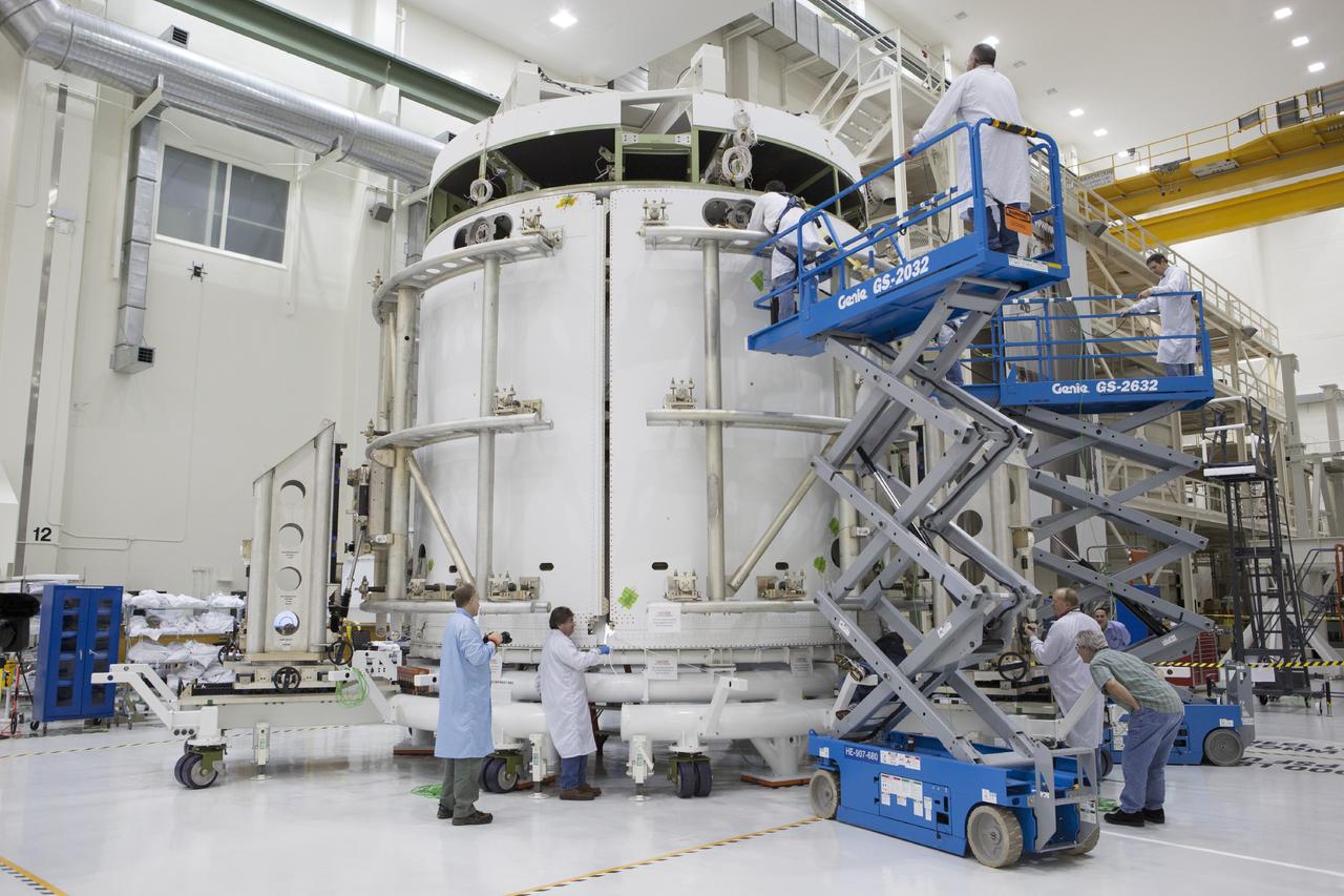 CAPE CANAVERAL, Fla. – Inside the Operations and Checkout Building high bay at NASA’s Kennedy Space Center in Florida, technicians on scissor lifts and those stationed on the floor work on the installation of the second of three fairings on the service module for the Orion spacecraft. The Orion spacecraft is being prepared for its first unpiloted flight test, Exploration Flight Test-1, or EFT-1, scheduled for launch atop a Delta IV rocket in September 2014. The Orion spacecraft is designed to carry astronauts to destinations not yet explored by humans. It will have emergency abort capability, sustain the crew during space travel and provide safe re-entry from deep space return velocities. Orion is scheduled to launch atop NASA’s Space Launch System rocket in 2017. For more information, visit http://www.nasa.gov/orion. Photo credit: NASA/Dimitri Gerondidakis