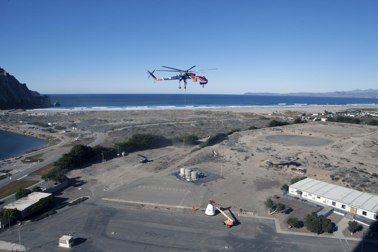 MORRO BAY, Calif. – A SpaceX Dragon test article is lifted under an Erickson Sky Crane helicopter before a test to evaluate the spacecraft's parachute deployment system as part of a milestone achievement under its Commercial Crew Integrated Capability agreement with NASA's Commercial Crew Program. The parachute test took place over the Pacific Ocean, off the coast of Morro Bay, Calif. Photo credit: NASA/Kim Shiflett